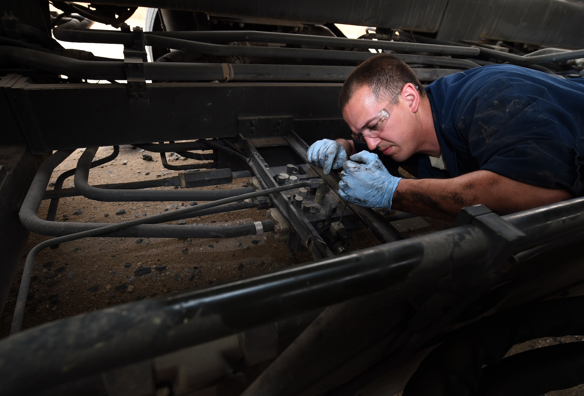 Staff Sgt. Matthew Trevino, a 386th Expeditionary Logistics Readiness Squadron material handling equipment mechanic, checks for defects on the solenoids of a 60K cargo loader at an undisclosed location in Southwest Asia, March 15, 2016. The material handling equipment section of the vehicle maintenance flight is responsible for maintaining and servicing heavy equipment on base such as fire trucks, cargo loaders, and forklifts. (U.S. Air Force photo by Staff Sgt. Jerilyn Quintanilla) 