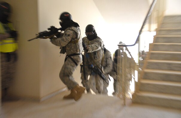 Airmen assigned to the 879th Expeditionary Security Forces Squadron at Eskan Village, Southwest Asia, quickly clear a building during a training exercise March 25. Training exercises help first responders maintain their readiness level. Explosive ordnance technicians, medics and emergency management professionals also participated in the exercise. (U.S. Air Force photo by Tech. Sgt. James Land)
