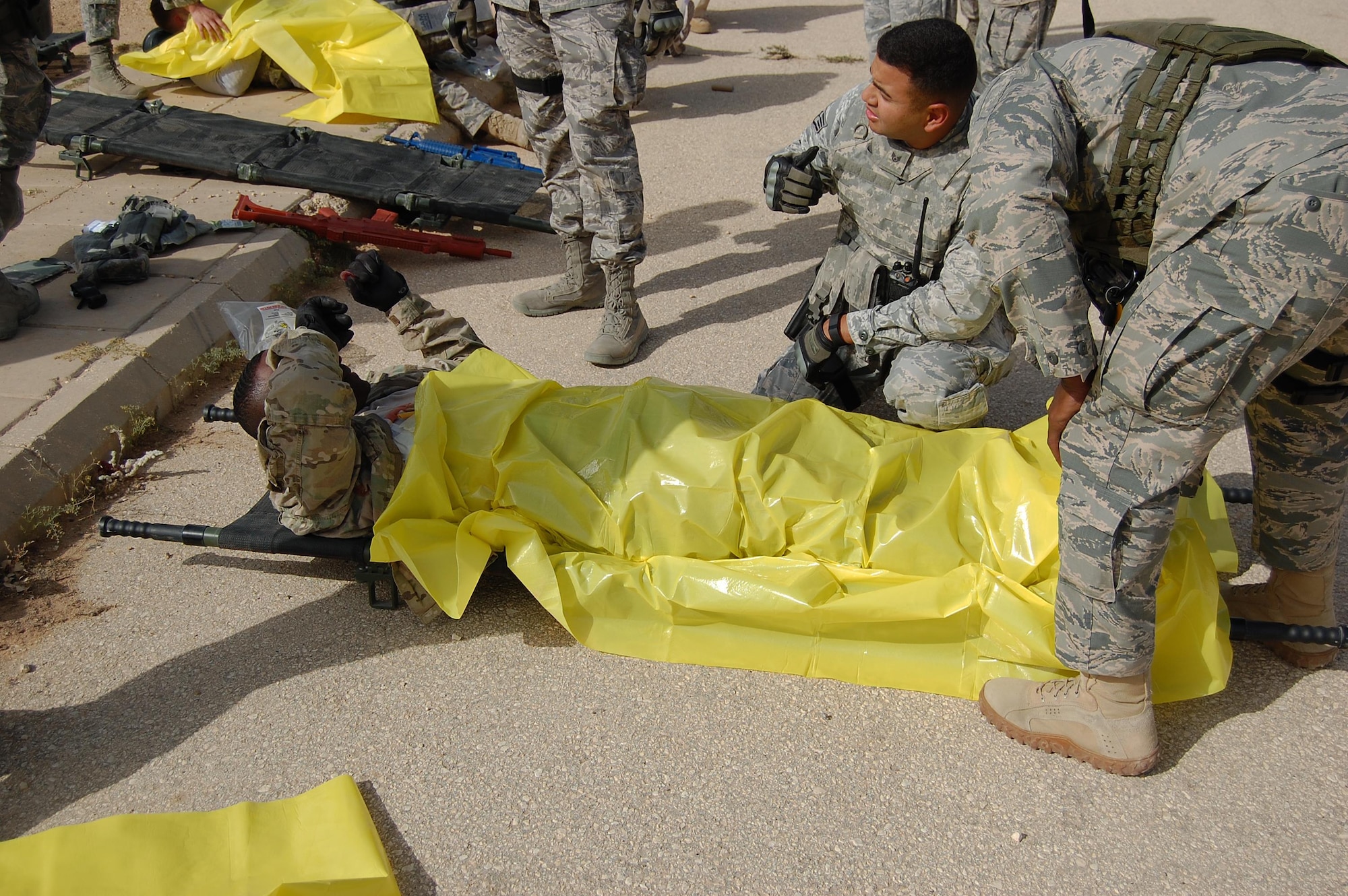 Airmen assigned to the 879th Expeditionary Security Forces Squadron at Eskan Village, Southwest Asia, treat victims of mock explosions and small arms fire during a training exercise March 25. Training exercises help first responders maintain their readiness level. Explosive ordnance technicians, medics and emergency management professionals also participated in the exercise. (U.S. Air Force photo by Master Sgt. William Burrows)