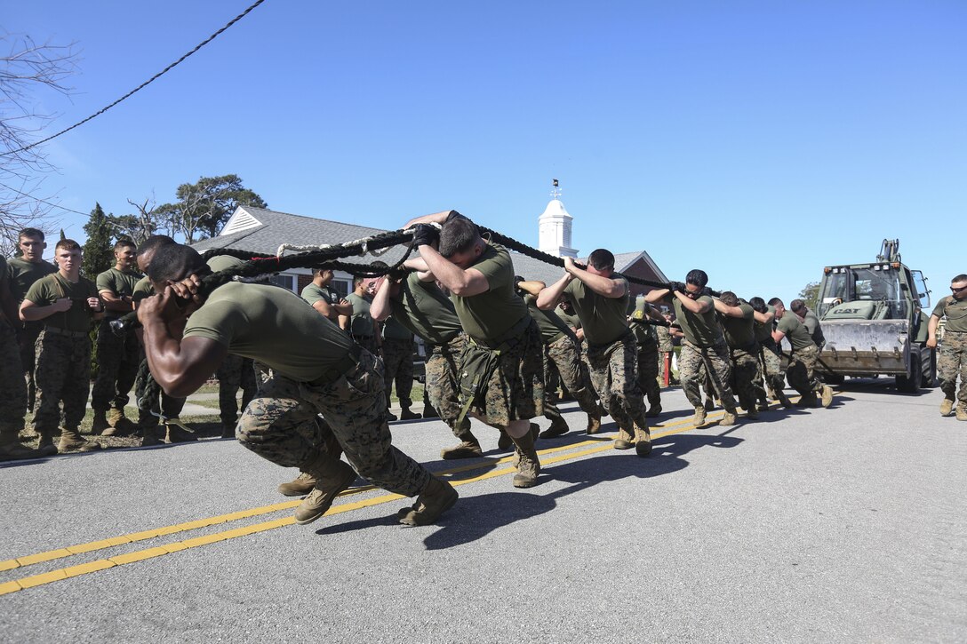 Teams of Marines from participating commands pulled together during a tractor tow event at the St. Patrick's Day Engineer Field Meet. Teams were required to pull the tractor from the starting line on an incline for a competitive time. 