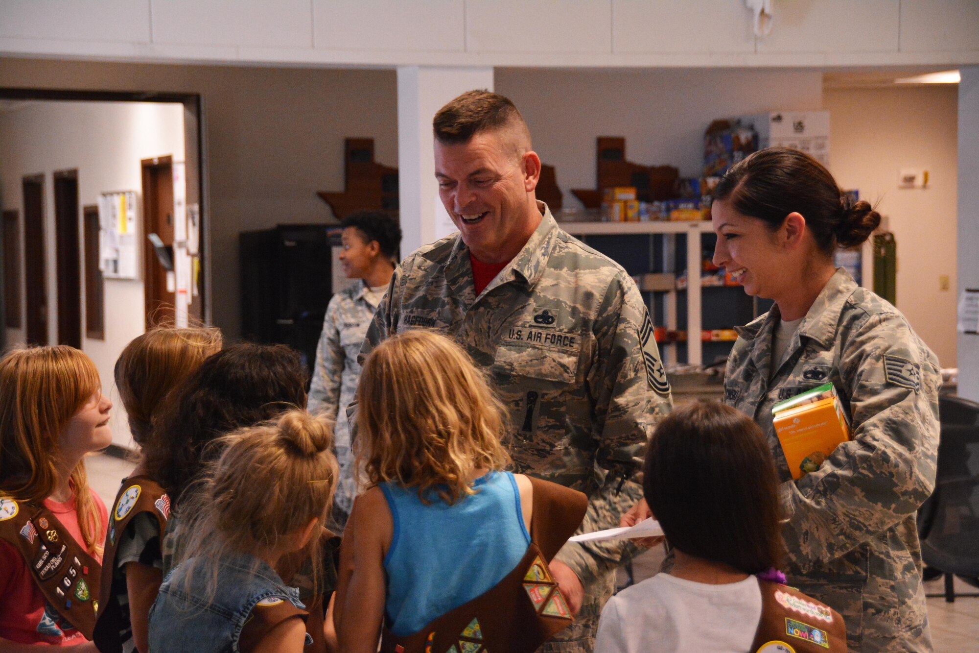 Chief Master Sgt. Eric Hagedorn, 301st Aircraft Maintenance Squadron superintendent, and Staff Sgt. Tiffany Karwacinski, 301 AMXS weapons technician, talks with girl scouts about cookies March 6 here. Troop 1651 handed out more than 200 boxes of cookies to Airmen within the 301st Fighter Wing. (U.S. Air Force photo by Staff Sgt. Samantha Mathison)