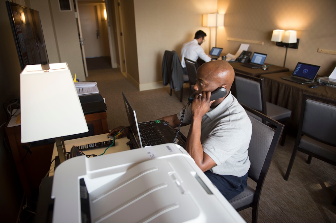 Air Force Tech. Sgt. Demond Bush makes a phone call in a communications room set up in the hotel where Defense Secretary Ash Carter and his staff stayed during a recent trip to the West Coast. The USAF tech support staff provides 24/7 access to secure networks, Internet, printers and phones. Air Force photo