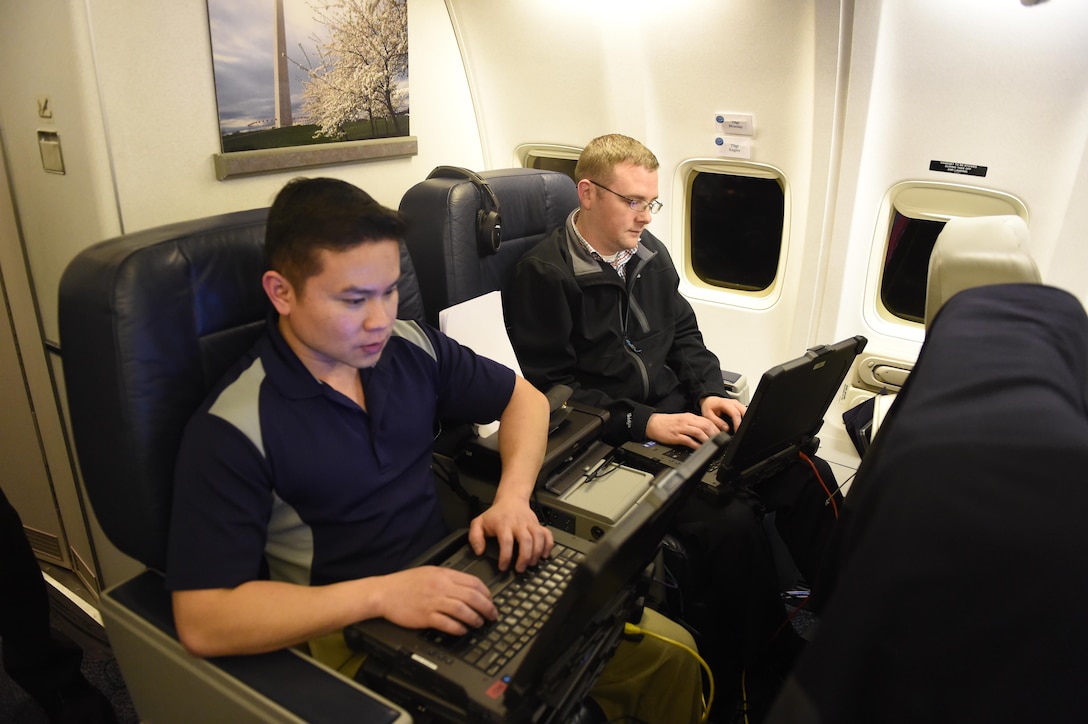 Air Force Tech. Sgt. Jacques Mcanlay, left, and Air Force Tech. Sgt. Jared Engler provide tech and communications support to Defense Secretary Ash Carter and his staff aboard a C-32 military aircraft during a recent trip to the West Coast. Air Force photo