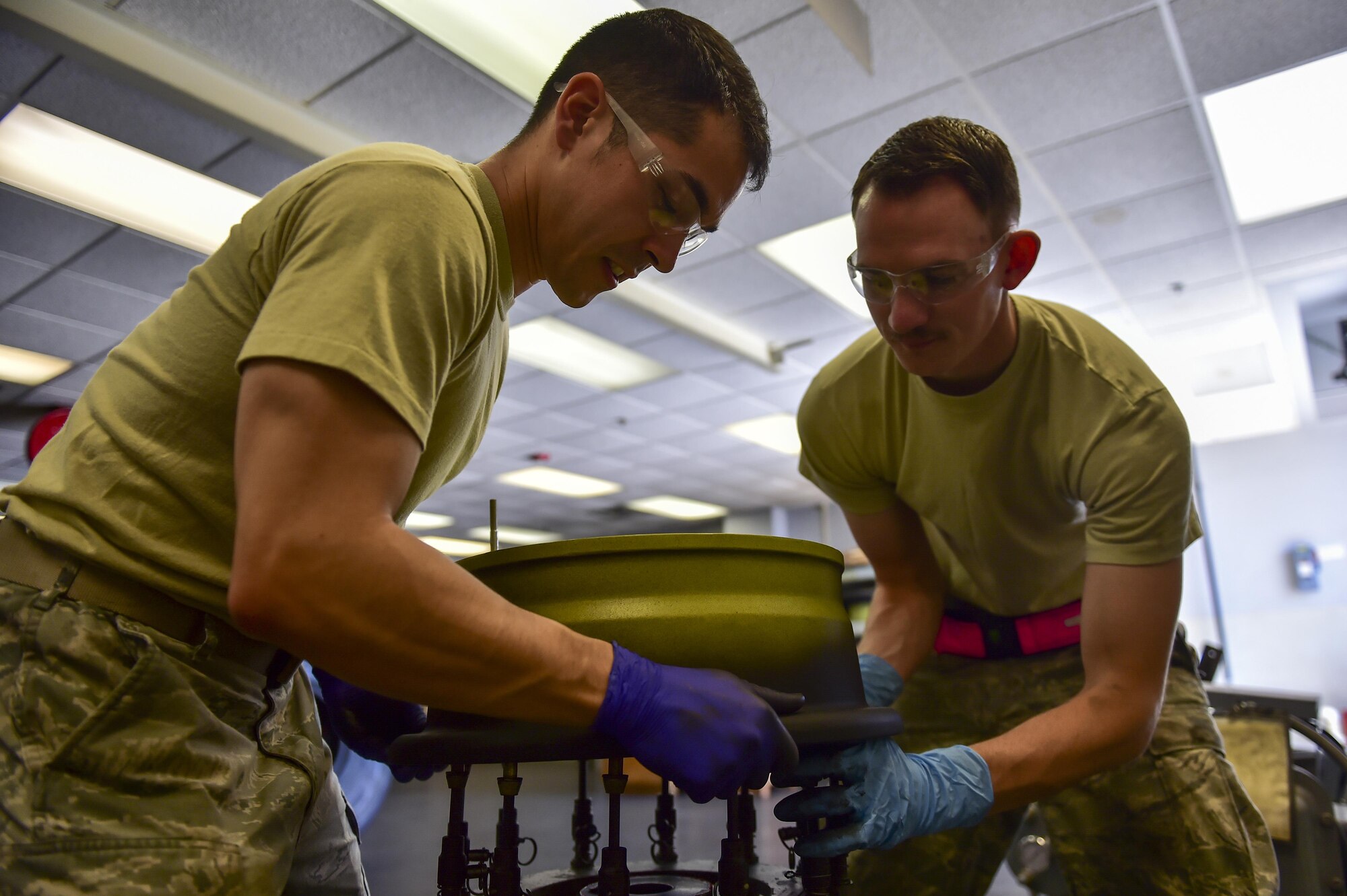 Senior Airman David Marzano and Senior Airman Shane Schubot, wheel and tire technicians with the 1st Special Operations Maintenance Squadron, place an aircraft wheel on a universal build-up stand at Hurlburt Field, Fla., March 30, 2016. The universal build-up stand provides a simple, safe and reliable means of assembling and disassembling main and nose aircraft wheels. (U.S. Air Force photo by Senior Airman Jeff Parkinson)