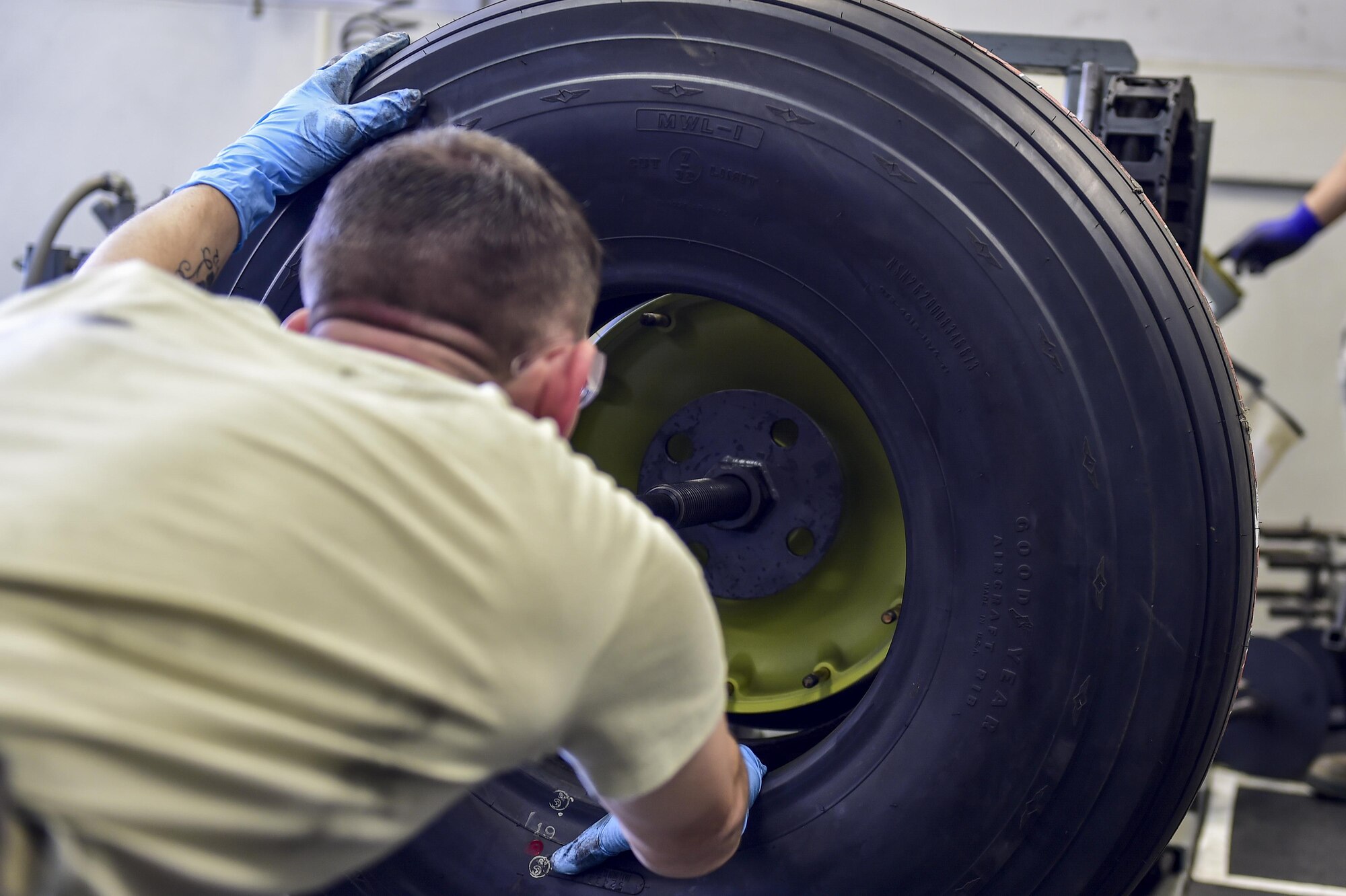 Senior Airman Shane Schubot, a wheel and tire technician with the 1st Special Operations Maintenance Squadron, places a C-130 nose tire onto a universal build-up stand at Hurlburt Field, Fla., March 30, 2016.  The universal build-up stand provides a simple, safe and reliable means of assembling and disassembling main and nose aircraft wheels. (U.S. Air Force photo by Senior Airman Jeff Parkinson)