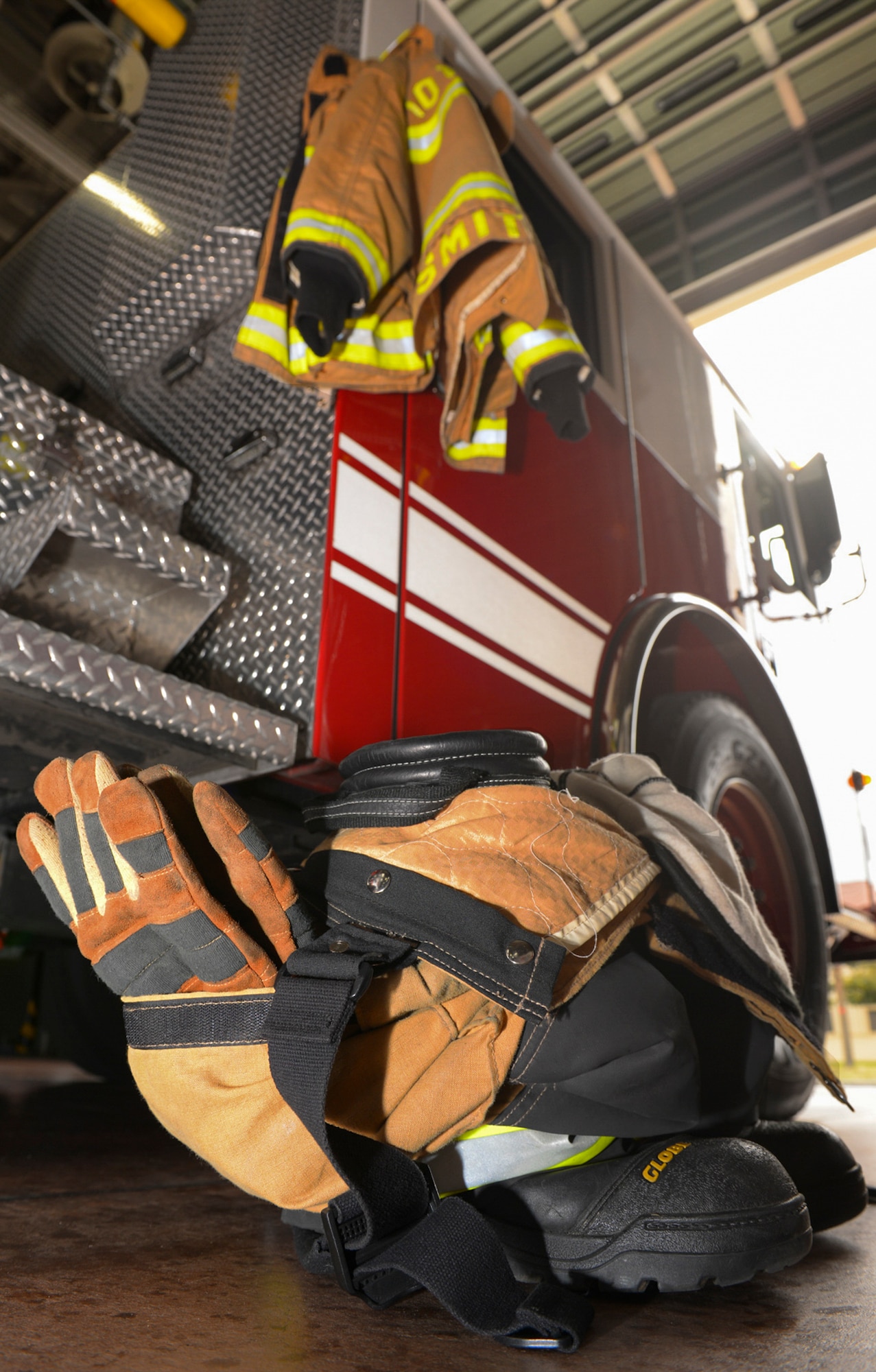 Fire protection equipment is arranged beside a fire truck at Yokota Air Base, Japan, March 30, 2016. The 374th Civil Engineer Squadron fire and emergency services flight arranges fire protection equipment to minimize donning time and maximize emergency response speed.  (U.S. Air Force photo by Airman 1st Class Elizabeth Baker/Released)