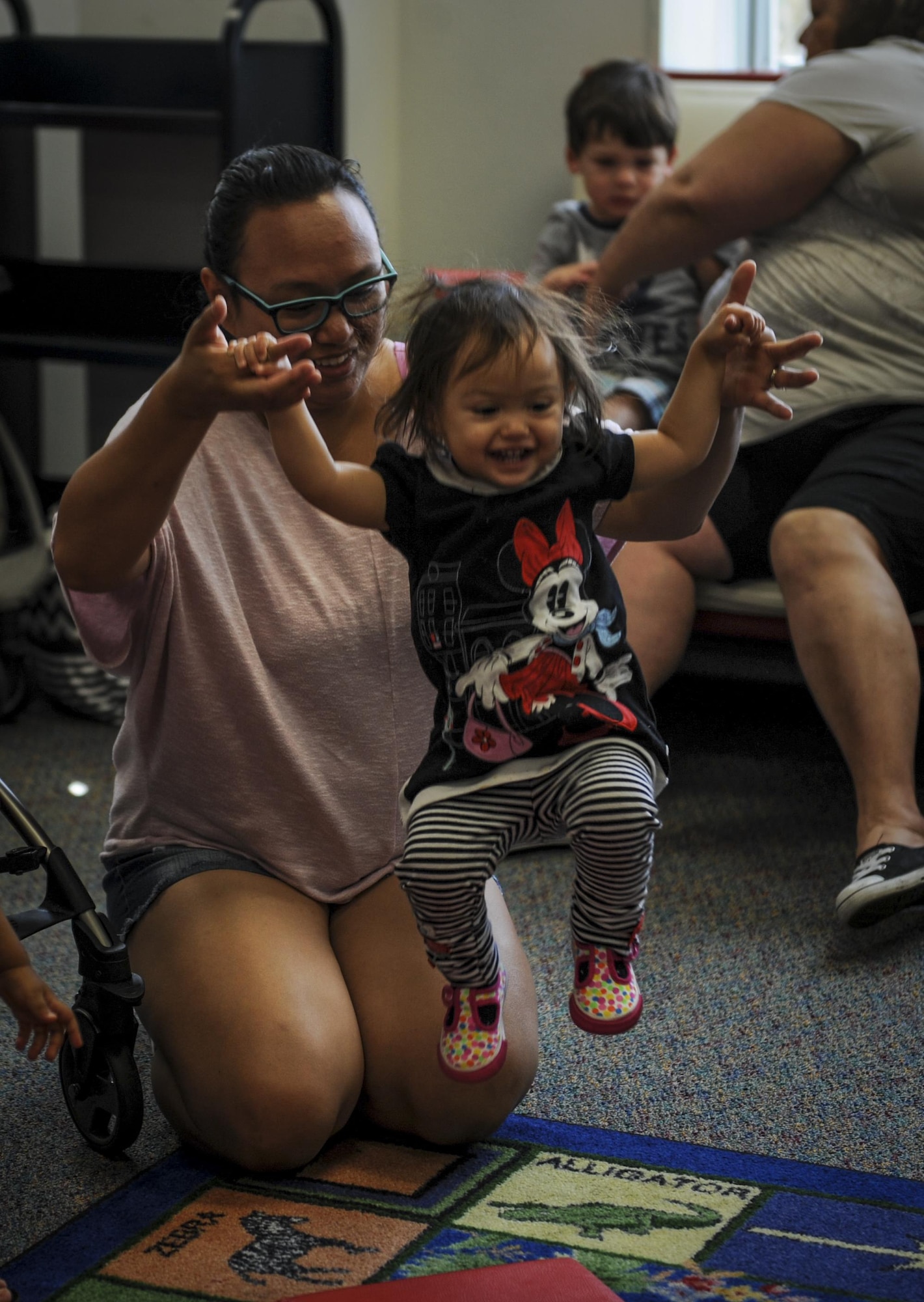 A mother and daughter play while the group participates in a physical activity before reading time at the library, Hurlburt Field, Fla., March 31, 2016. Every Thursday, the library hosts a reading time with a guest speaker who reads to children. This event enables parents to network and helps children work on literacy skills, fine motor capabilities and social skills. (U.S. Air Force photo by Senior Airman Meagan Schutter)