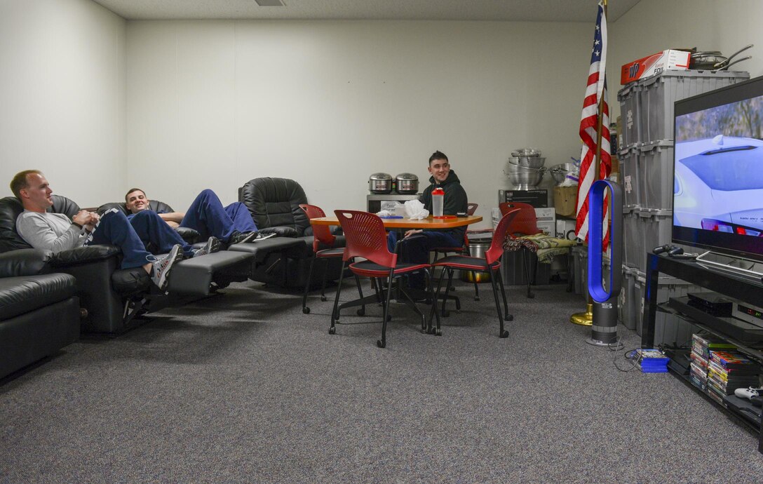 U.S. Air Force Staff Sgt. Kyle Wirth, crew chief, Airman 1st Class Brendan Ryan, firefighter, and Senior Airman Stephen Taylor, driver operator, all from the 374th Civil Engineer Squadron fire and emergency services flight, relax in the day room during their down time at Yokota Air Base, Japan, March 28, 2016. The 374th CES/FEF personnel have bedrooms, showers, a gym and a kitchen available during 24-hour shifts at the fire department building, minimizing their need to leave the building and maximizing their ability to access emergency response equipment. (U.S. Air Force photo by Airman 1st Class Elizabeth Baker/Released)