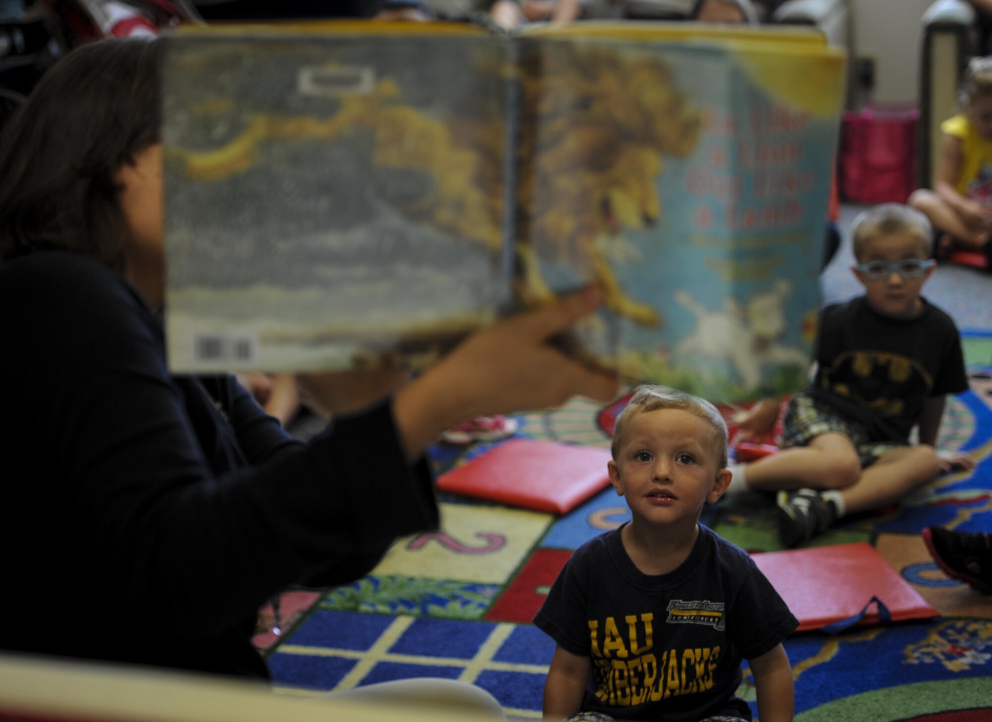 A child listens to the guest reader at the library, Hurlburt Field, Fla., March 31, 2016. Every Thursday, the library hosts a reading time with a guest speaker who reads to children. This event enables parents to network and helps children work on literacy skills, fine motor capabilities and social skills. (U.S. Air Force photo by Senior Airman Meagan Schutter)