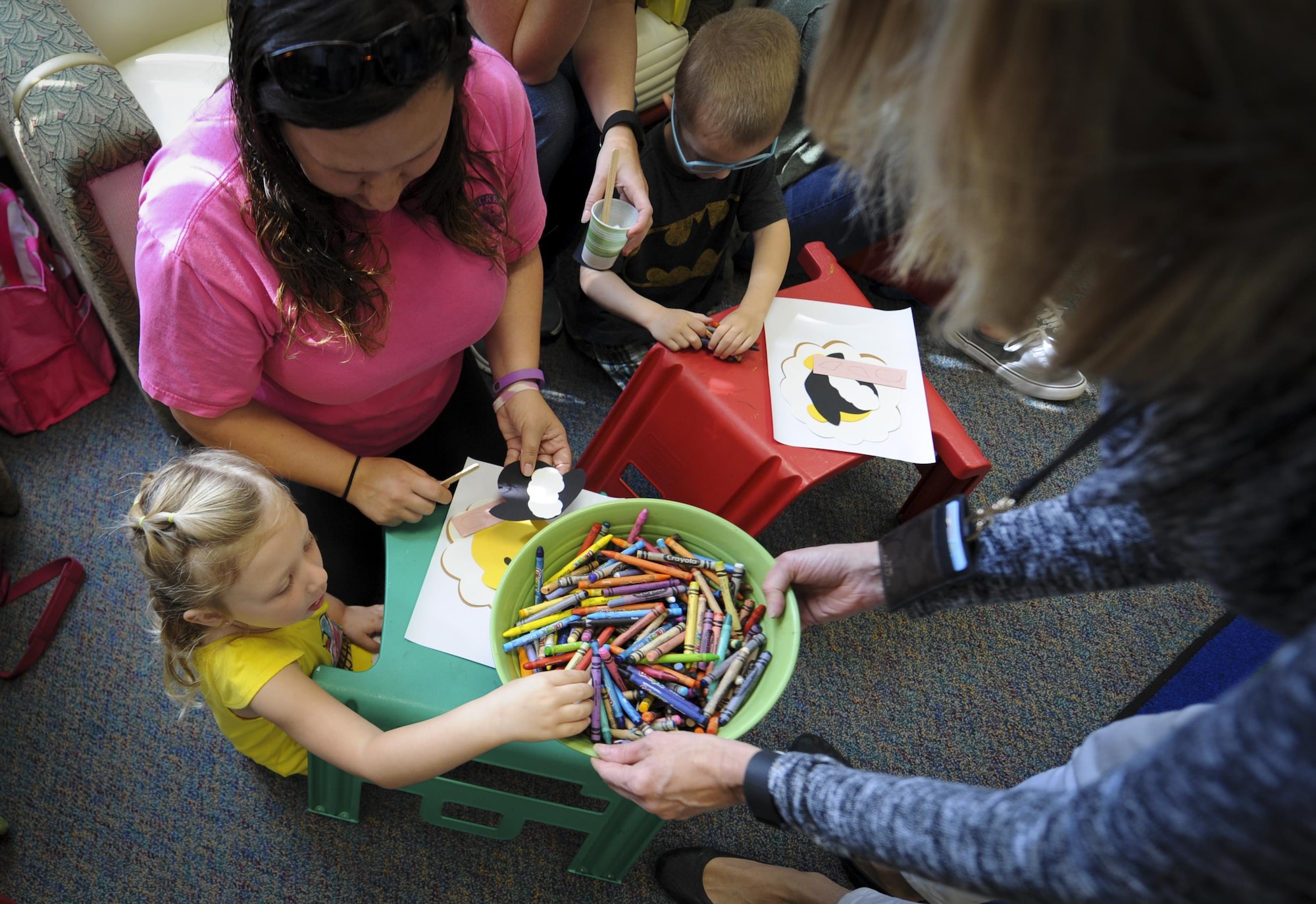 A child reaches for a crayon during craft time at the library, Hurlburt Field, Fla., March 31, 2016. Every Thursday, there is a reading time that hosts a guest speaker to read to children. During the event, there are songs and physical activities, as well as a craft time after the stories for children and parents to participate in. The goal is to help children work on literacy skills, fine motor capabilities and social skills. (U.S. Air Force photo by Senior Airman Meagan Schutter)