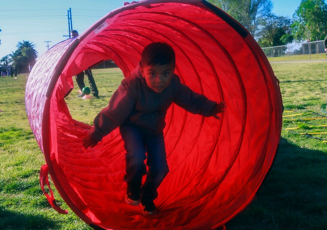 MARINE CORPS BASE CAMP PENDLETON, Calif. – Nathaniel Dominguez runs through a tunnel during the Physical Education Fitness Challenge at North Terrace Elementary, March 25, 2016. Approximately 30 Marine volunteers with the Single Marine Program facilitated a series of exercises and competitions including an obstacle course relay race and tug-of-war. The challenge encourages children to stay active and helps Marines engage with their local community. Dominguez is a kindergarten student at North Terrace Elementary. (U.S. Marine Corps photo by Lance Cpl. Caitlin Bevel/RELEASED)