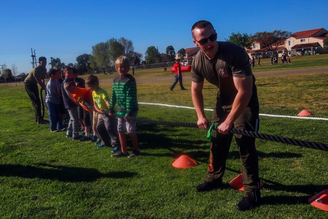 MARINE CORPS BASE CAMP PENDLETON, Calif. – Lance Cpl. Johnathan Watkins prepares a group of second grade students to compete at tug-of-war at North Terrace Elementary March 25, 2016. Approximately 30 Marine volunteers with the Single Marine Program facilitated a series of exercises and competitions including an obstacle course relay race and tug-of-war as part of a Physical Education Fitness Challenge. The challenge encourages children to stay active and helps Marines engage with their local community. Watkins, a native of Huntington Beach, Calif., is a ground radio repairman with 9th Communication Battalion, I Marine Expeditionary Force Headquarters Group. (U.S. Marine Corps photo by Lance Cpl. Caitlin Bevel/RELEASED)