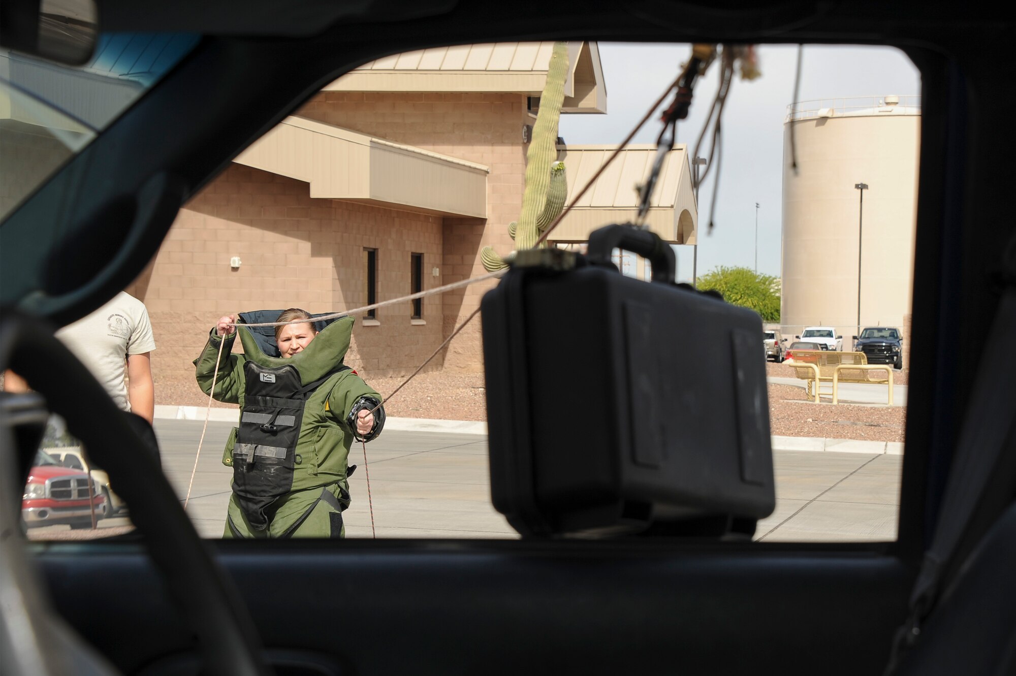 U.S. Air Force Master Sgt. Hass, 355th Civil Engineer Squadron first sergeant, uses a hook and line procedure to remotely remove a suspicious package from a vehicle during the Comprehensive Airman Fitness Month Fire Department Fitness Challenge at Davis-Monthan Air Force Base, Ariz., March 31, 2016.  The event was hosted by the 355th Civil Engineer Squadron’s explosive ordnance disposal and fire emergency service flights in coordination with the Community Support Center with the objectives of embracing team building, showing the links between different CAF pillars, and encouraging Airmen to challenge themselves. (U.S. Air Force photo by Airman 1st Class Mya M. Crosby/Released) (U.S. Air Force photo by Airman 1st Class Mya M. Crosby/Released)