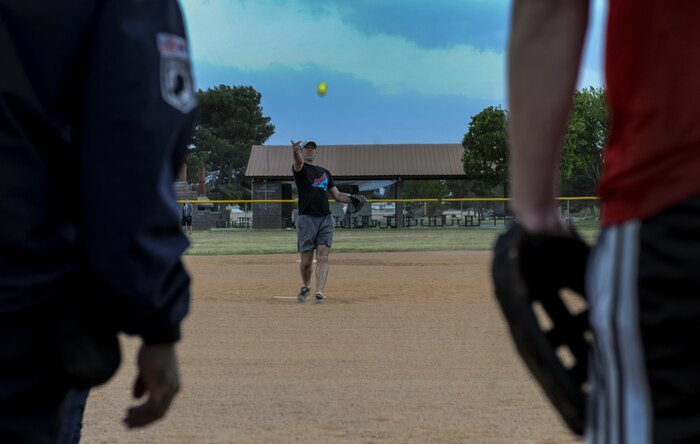 A member of the 57th Operations Support Squadron team from Creech Air Force Base pitches against the 30th Reconnaissance Squadron during the first intramural game of the day at Nellis Air Force Base, Nev., March 29, 2016.  With the season beginning in the middle of March, the league is planned to be finished during May before the summer temperatures get to hot to play. (U.S. Air Force photo by Airman 1st Class Kevin Tanenbaum)