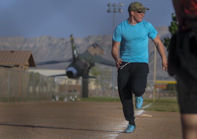 A 57th Maintenance Squadron Munitions Flight intramural softball team member sprints towards home plate during a practice before a game at Nellis Air Force Base, Nev., March 28, 2016. The Airmen hope to take away a healthier atmosphere, both physically and mentally. The dynamic of teams allows for a fun, competitive environment that gets teams interacting within and outside their units. (U.S. Air Force photo by Airman 1st Class Kevin Tanenbaum)