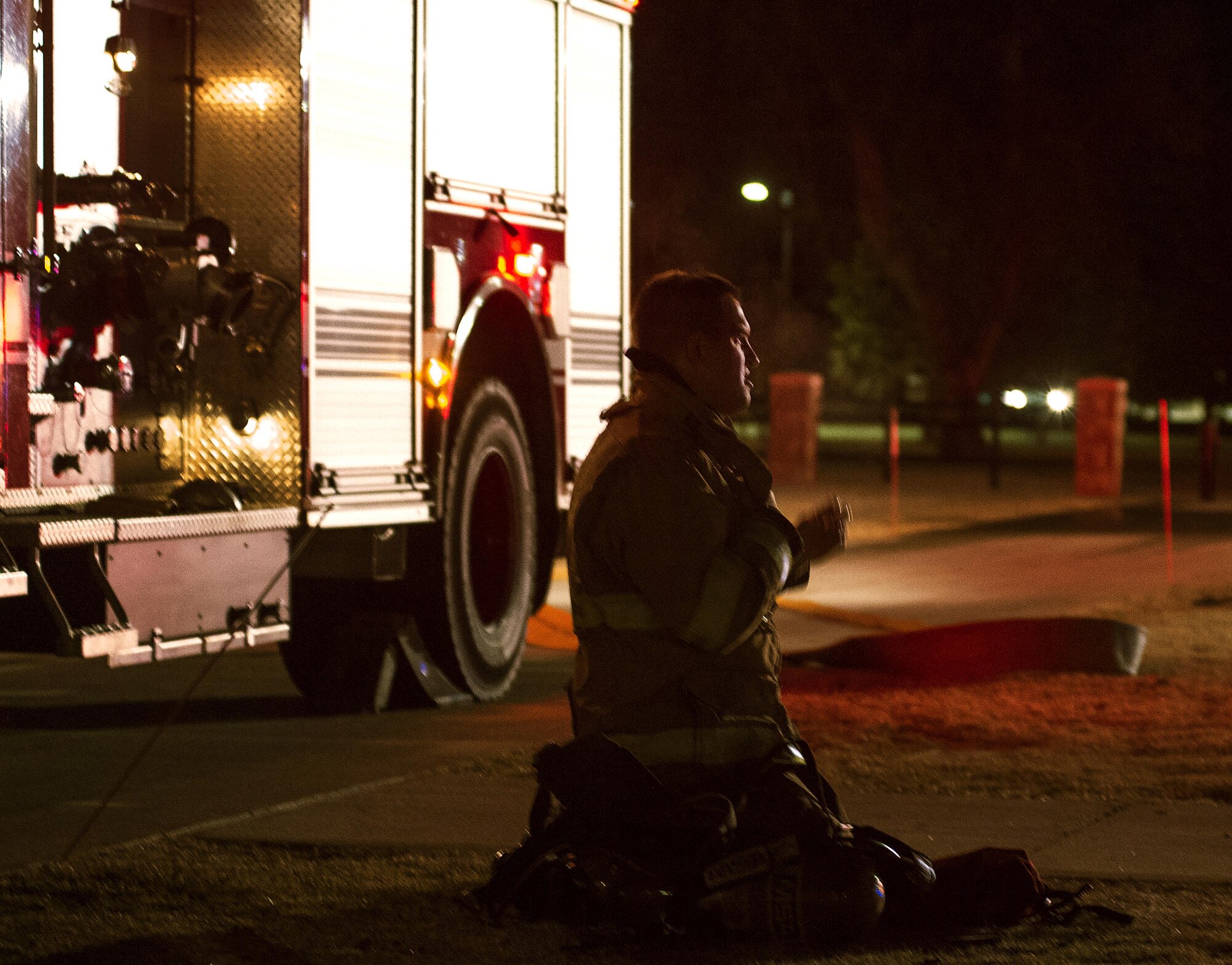 A firefighter with the F.E. Warren Air Force Base, Wyo., Fire Department takes his air tank and mask off the evening of March 9, 2016, outside of the 90th Missile Wing headquarters building. The fire department responded to a fire alarm after the custodian smelled smoke in the building. (U.S. Air Force photo by R.J. Oriez)