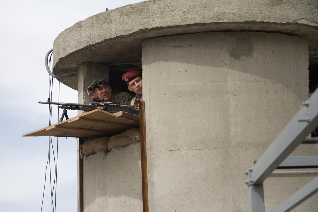 U.S. Army Maj. Gen. Gary J. Volesky, left, the commander of Combined Joint Task Force Land Component Command - Operation Inherent Resolve, and a French soldier peer out of a guard tower at Camp Monsabert, Iraq, March 24, 2016. Volesky visited the camp to meet with Task Force Monsabert senior leaders and to receive a briefing on the ongoing training effort there. Army National Guard photo by Sgt. Katie Eggers