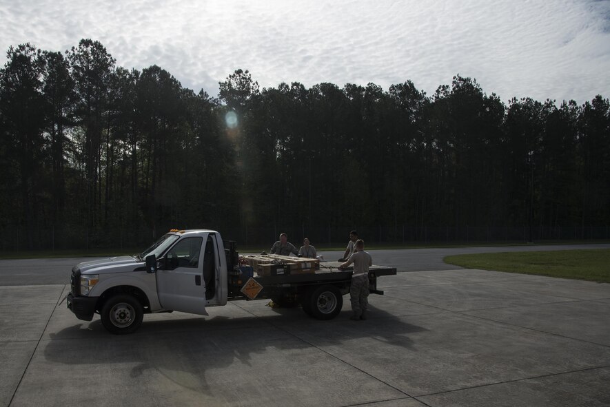 U.S. Air Force Airmen from the 23d Equipment Maintenance Squadron munitions storage unit load munitions onto a truck bed, March 31, 2016, at Moody Air Force Base, Ga. Ammo crew members are responsible for filling orders of live, nonexplosive and inert munitions that need to be inspected.   (U.S. Air Force photo by Airman 1st Class Janiqua P. Robinson/Released)