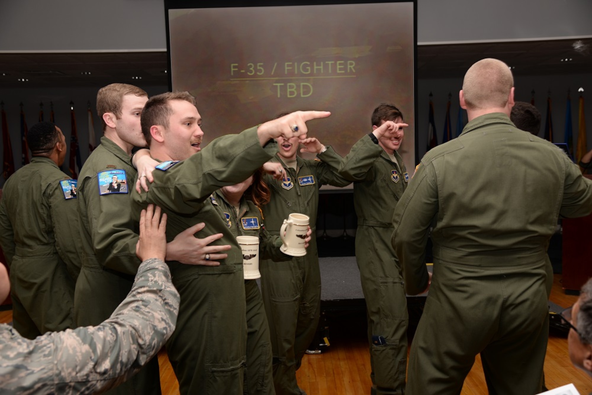 Second Lt. Austin Hornsby, Specialized Undergraduate Pilot Training Class 16-07, celebrates with his flightmates after receiving his assignment to fly the F-35 Lightning II at 16-07 assignment night on Columbus Air Force Base, Mississippi, March 25. Hornsby will be the first SUPT student ever to accept the challenge of piloting the F-35. (U.S. Air Force photo illustration/Senior Airman Stephanie Englar)