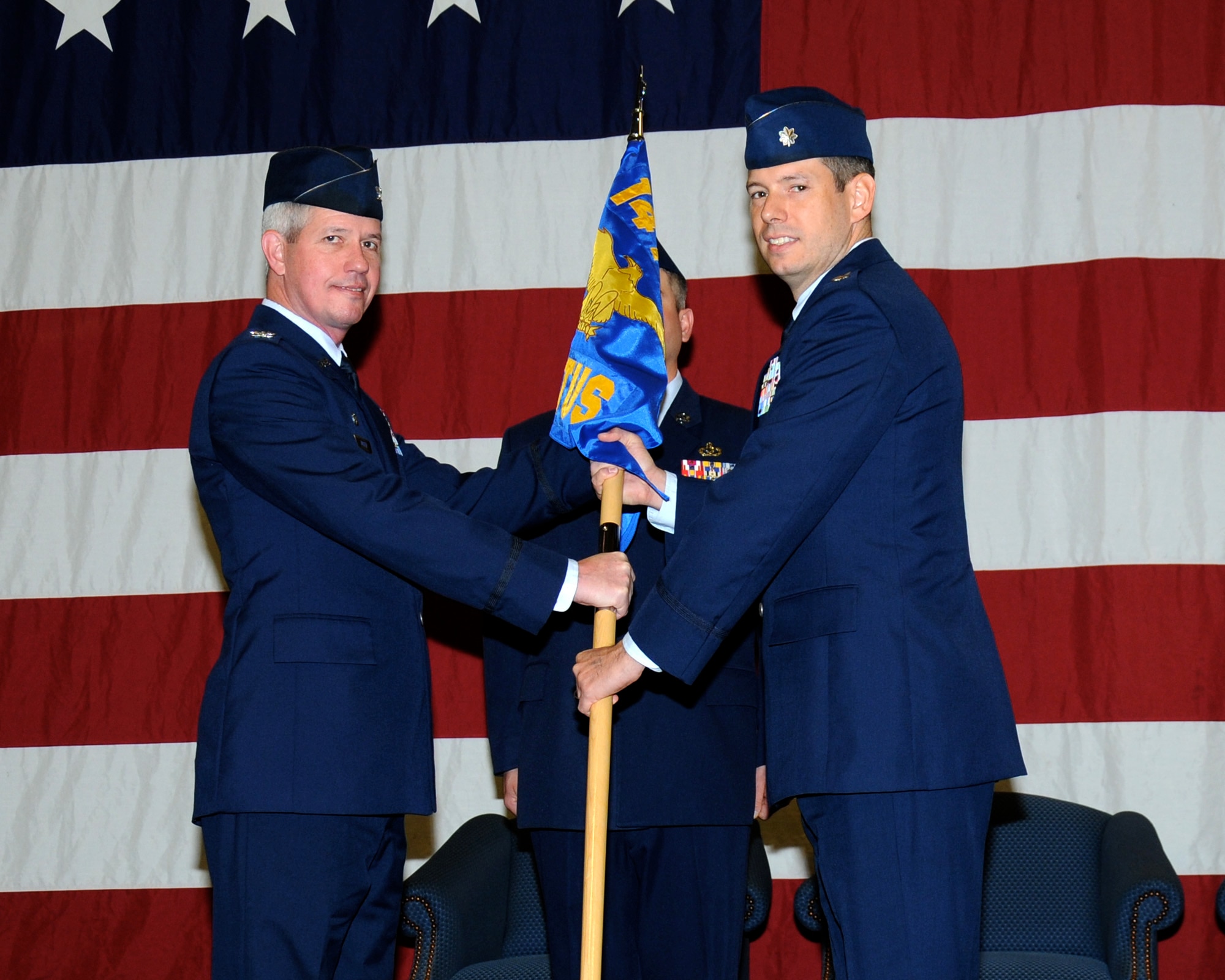 Col. James Boster, 14th Operations Group Commander, passes the 14th Student Squadron guidon to Lt. Col. Marc Deshaies, the new 14th STUS Commander, at a change of command ceremony March 31 at Columbus Air Force Base, Mississippi. Deshaies was formerly the 14th Flying Training Wing Director of Staff. (U.S. Air Force photo/Sharon Ybarra) 
