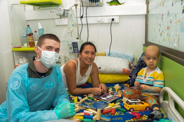 Capt. Stephen Kasteler, flight doctor with the F-22 Demonstration Team, poses with a child at San Juan de Dios hospital in Santiago, Chile, March 31, 2016.  The Airmen are in Chile to participate in the 2016 FIDAE Air and Space Trade Show and spent some of their down-time visiting children in multiple hospitals.  (U.S. Air Force photo by Tech. Sgt. Heather Redman/Released)