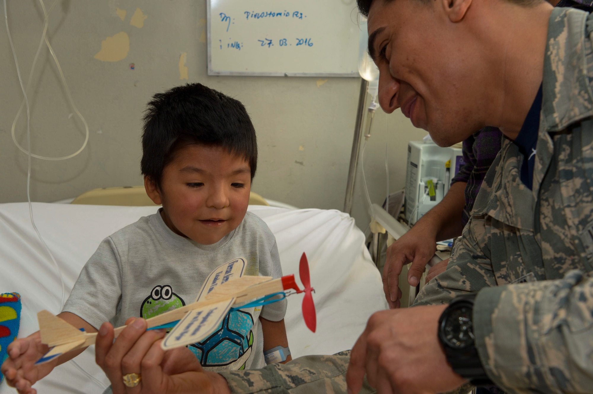 Staff Sgt. Juan Gomez-Navarro, fuel systems specialist with the F-22 Demonstration Team, helps a child build a plane at San Juan de Dios hospital in Santiago, Chile, March 31, 2016.  The Airmen are in Chile to participate in the 2016 FIDAE Air and Space Trade Show and spent some of their down-time visiting children in multiple hospitals.  (U.S. Air Force photo by Tech. Sgt. Heather Redman/Released)