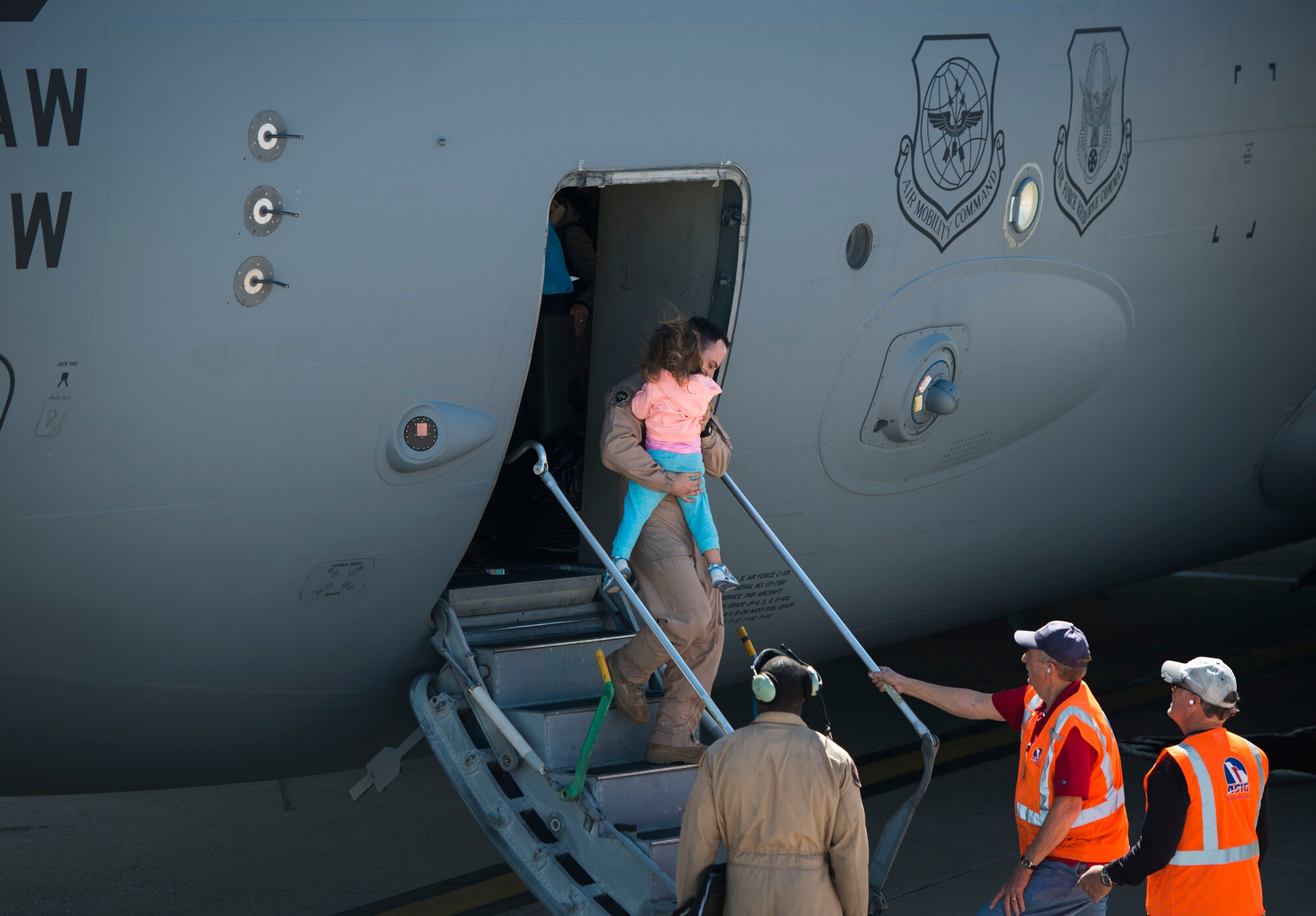 An Air Force crewmember carries a military dependent out of a C-17 Globemaster III at Baltimore Washington International Airport, Md., April 1, 2016. Defense Department dependents in Adana, Izmir and Mugla, Turkey, were given an ordered departure by the State Department and Secretary of Defense. (U.S. Air Force photo/Staff Sgt. Andrew Lee)