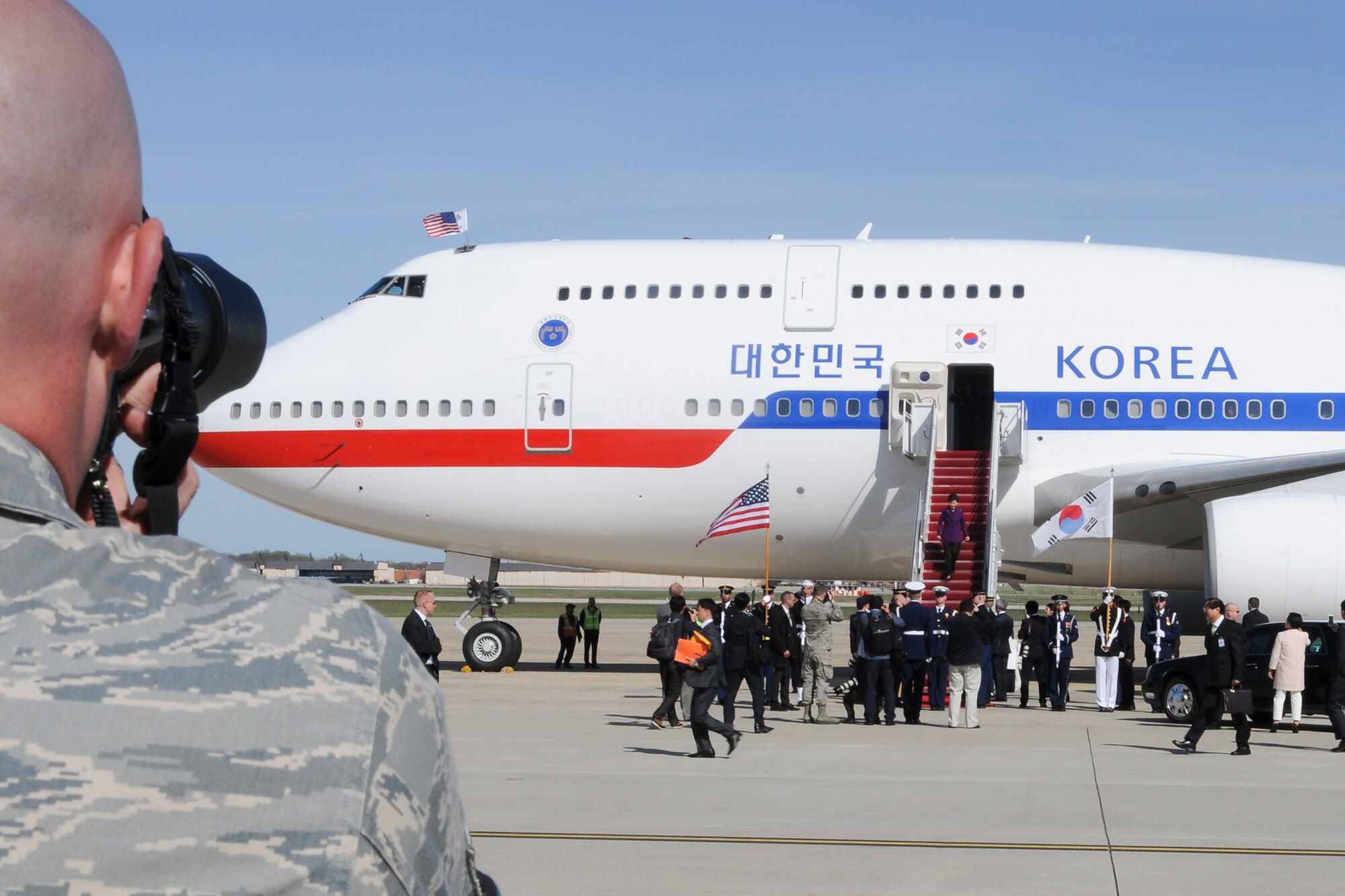 Technical Sgt. Malachi Woodlee, 459th Maintenance Squadron repair/reclamation craftsman and Nuclear Security Summit volunteer, takes pictures of the arrival of Park Geun-hye, President of South Korea, on the Joint Base Andrews, Md., flight line March 30. More than 20 international heads of state arrived here for the 2016 NSS held in Washington, D.C. The summit provides a forum for leaders to reinforce commitments to securing nuclear materials. (U.S. Air Force photo/Staff Sgt. Kat Justen)
