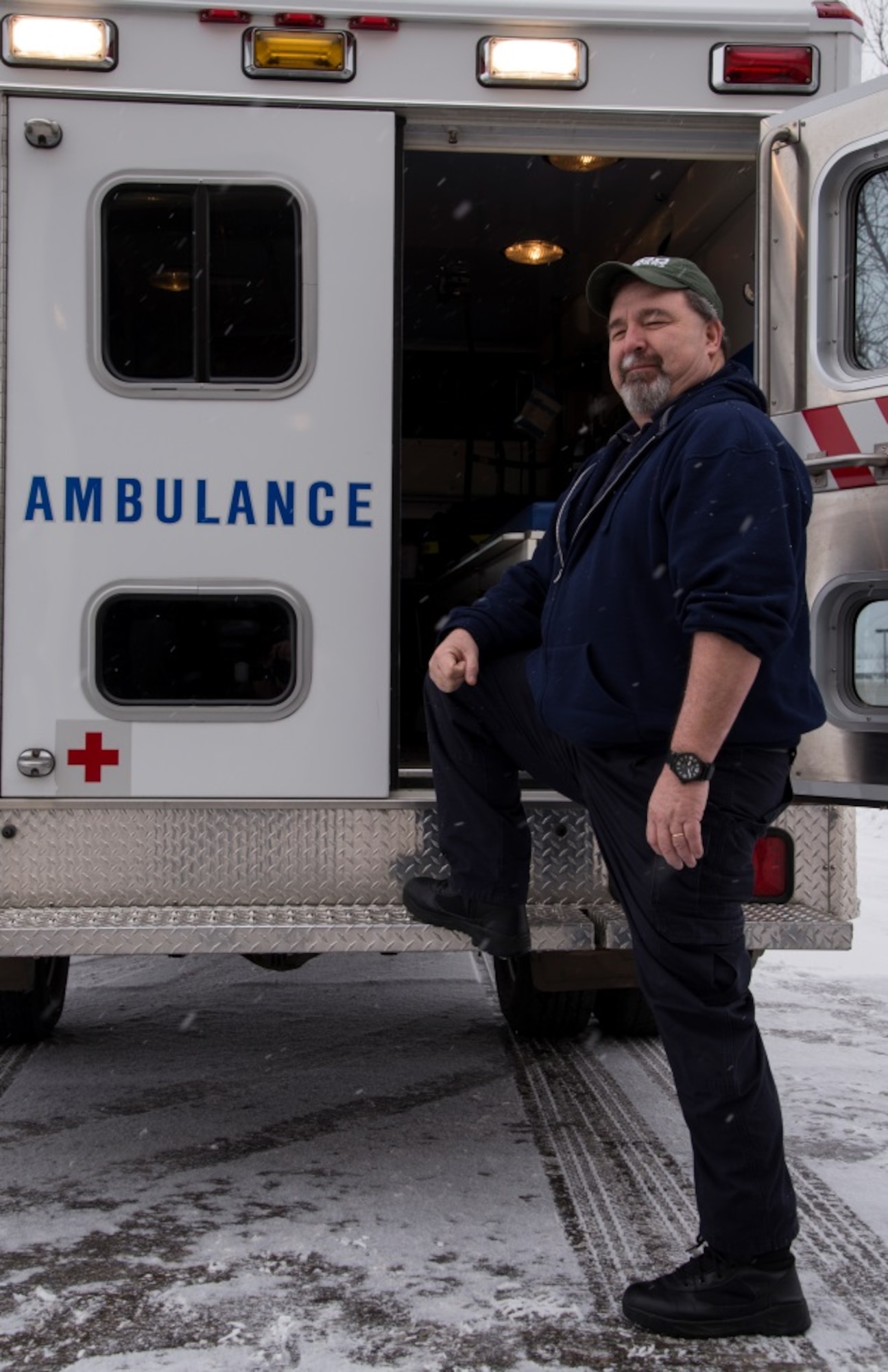 Gary August, 5th Medical Group field paramedic, poses next to his ambulance at Minot Air Force Base, N.D.,  March 18, 2016. Ambulance services personnel are on call 24/7, 365 days a year ready to respond to calls for medical aid and transport their patients quickly and safely downtown if needed. (U.S. Air Force photo/Airman 1st Class Christian Sullivan)