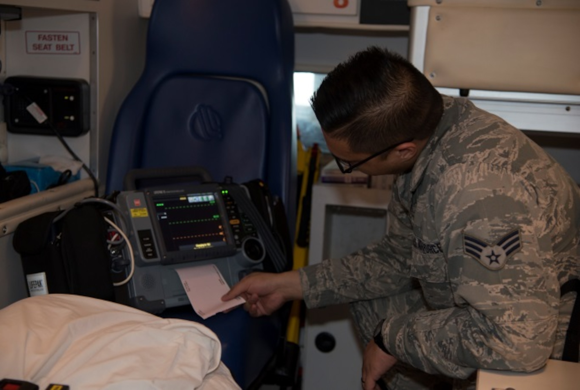 Senior Airman Lenard Catalan, 5th Medical Group emergency medical technician, checks his readings during a demonstration at Minot Air Force Base, N.D., March 18, 2016. Catalan and other civilian paramedics in his section work 24 to 72 hour shifts supporting the medical needs of base Airmen and their families.  (U.S. Air Force photo/Airman 1st Class Christian Sullivan)