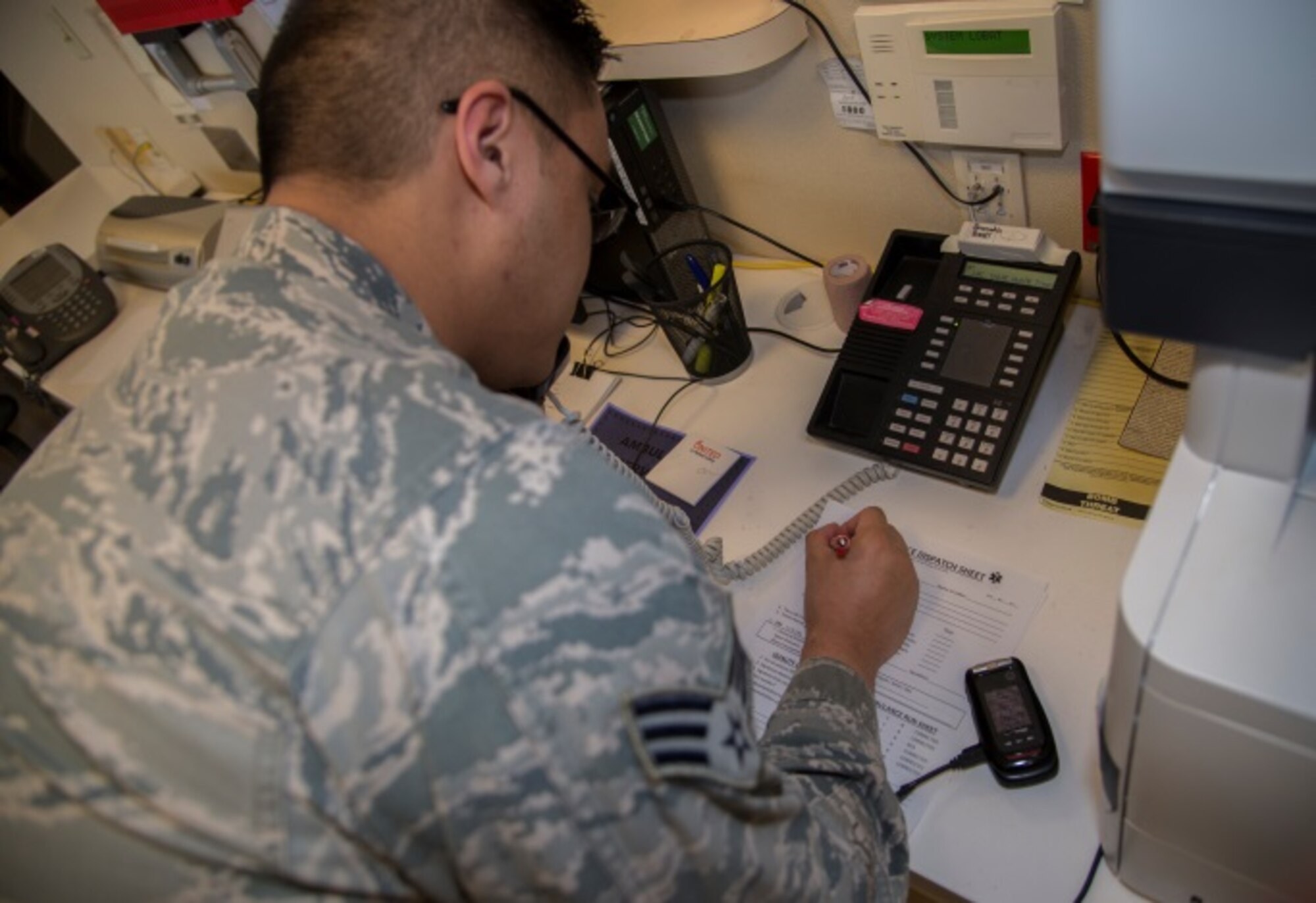 Senior Airman Lenard Catalan, 5th Medical Group emergency medical technician, prepares to write down the details of an emergency call during a demonstration at Minot Air Force Base, N.D., March 18, 2016. Being an EMT is a 24-hour job and can require any part of your medical knowledge at any time. (U.S. Air Force photo/Airman 1st Class Christian Sullivan)