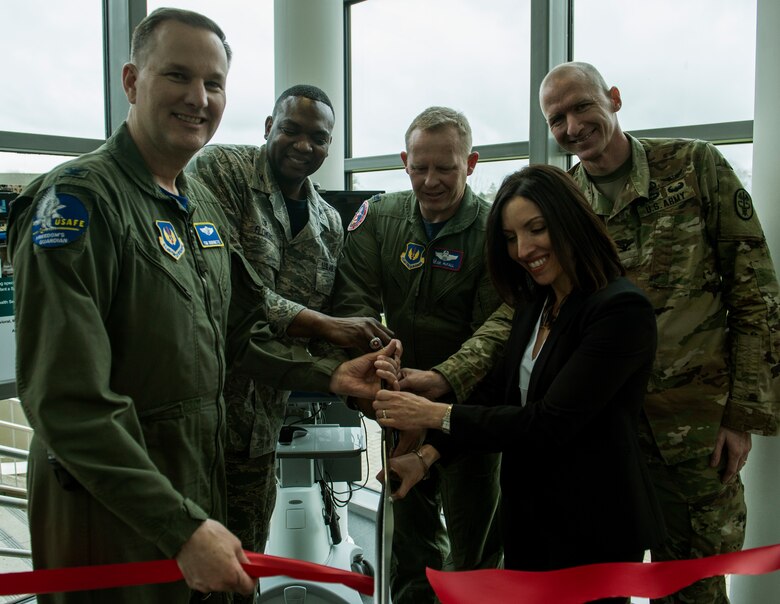 (From left to right) U.S. Air Force Col Timothy Robinette, U.S. Air Forces in Europe and Air Forces Africa command surgeon (left), Col. Alfred Flowers, 52nd Medical Group commander, Col. Joe McFall, 52nd Fighter Wing commander, U.S. Army Col. Kirk Waibel, Army Regional Health Command Europe Telehealth medical director, Alicia English, Army Regional Health Command Europe acting deputy to the command general, cut a ribbon during the 52nd MDG/Landstuhl Regional Medical Center Telehealth ribbon cutting ceremony inside the 52nd MDG clinic April 1, 2016, at Spangdahlem Air Base, Germany. The Telehealth program will allow patients from Spangdahlem Air Base to receive treatment from LRMC doctors without leaving the installation. (U.S. Air Force photo by Senior Airman Rusty Frank/Released)