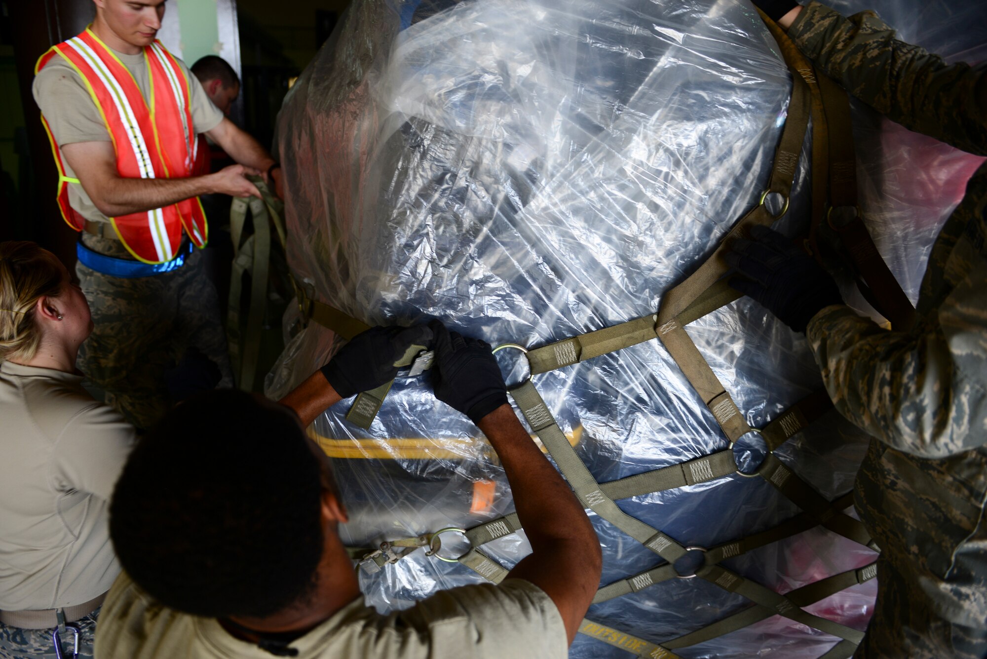 Members of the 728th Air Mobility Squadron along with volunteers, tie-down a pallet of luggage, March 31, 2016, at Incirlik Air Base, Turkey. Pallets of luggage were built for the departure of all Department of Defense dependents assigned to Incirlik Air Base. (U.S. Air Force photo by Staff Sgt. Caleb Pierce/Released)