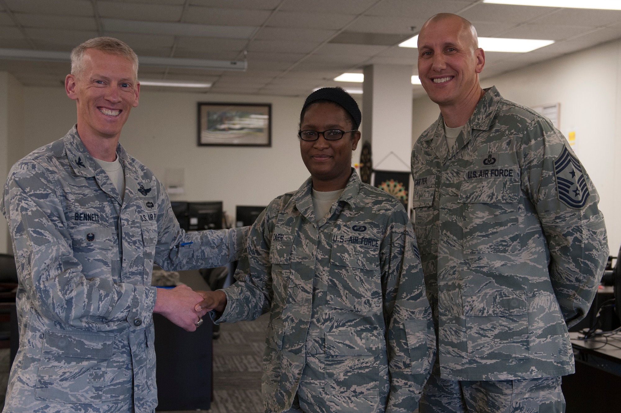 U.S. Air Force Col. Christopher Bennett, 19th Airlift Wing vice commander, and Chief Master Sgt. Kenneth Carter, 19th Airlift Wing command chief, congratulate Senior Airman Dorothy Carr, 19th Comptroller Squadron financial analyst, as the Combat Airlifter of the Week March 28, 2016, at Little Rock Air Force Base, Ark. Carr reviewed and certified $75,000 in supply and equipment purchases for the 19th Maintenance Group. (U.S. Air Force photo by Airman 1st Class Mercedes Taylor) 
