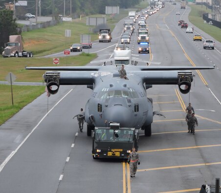Traffic crawls along behind a C-130H trainer and an F-84F Thunderstreak being towed down Ga. Highway 247 March 25, 2016. (U. S. Air Force photo by Roland Leach)
