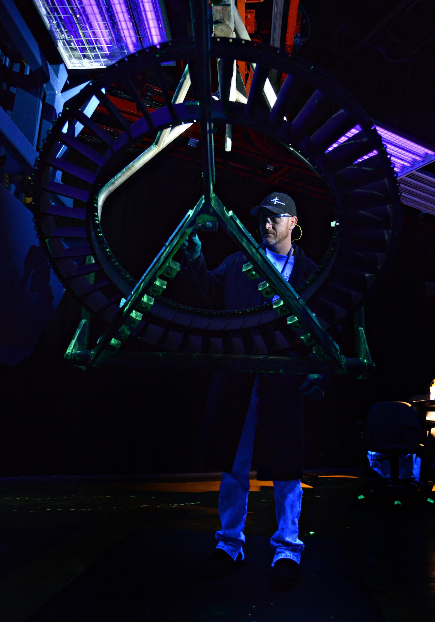 Ryan Thomas, a fluorescent penetrant inspector with the 548th Propulsion Maintenance Squadron, uses a black light on a “wagon wheel” to find any indication of cracks or other compromises to a part. The 548th PMXS’s Non-Destructive Inspection shop examines thousands of engine parts each year looking for hidden dangers that could potentially cause the part to fail. (Air Force photo by Kelly White/Released)