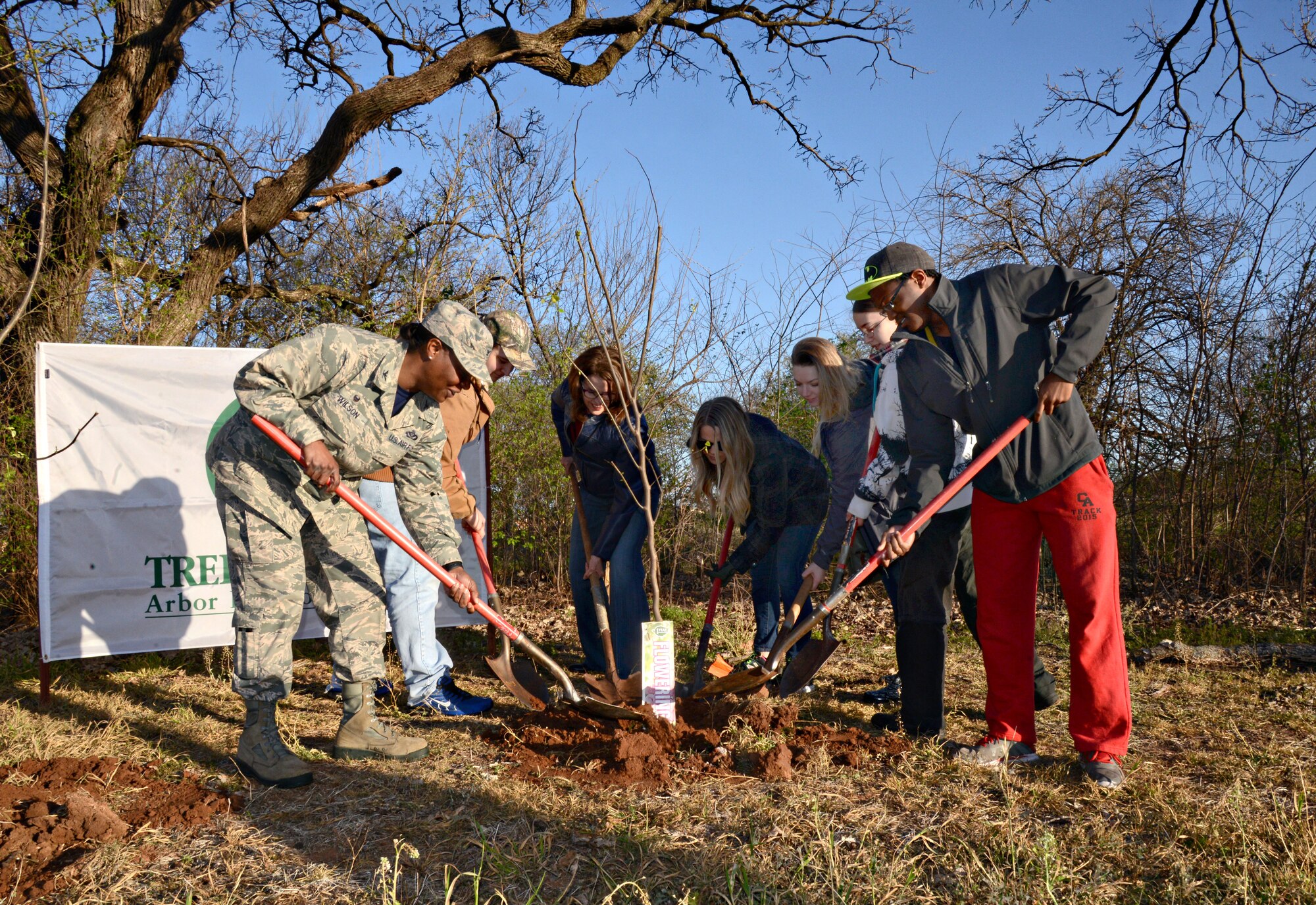 To commemorate Tinker’s Arbor Day March 25, Natural Resources staff and volunteers from the Rose State College Tinker Federal Credit Union Civic Leaders group planted 100 Eastern Redbud trees in the area near Crutcho Creek. Planting the ceremonial tree are, from left, 72nd Air Base Wing and Tinker Installation Commander Col. Stephanie Wilson, Colton Sutton, Cathy Scheirman, 72nd ABW Civil Engineering Directorate, Treysa Jones, Brittany Kemp, Rebecca Stokes and Jaydon Robinson. During the event, Colonel Wilson read an excerpt of the proclamation she signed, “We all must preserve and protect our vital woodlands for future generations. Tinker AFB is committed to protecting the environment while providing world-class support and service to Department of Defense and Air Force warfighters worldwide.” (Air Force photo by Kelly White/Released)