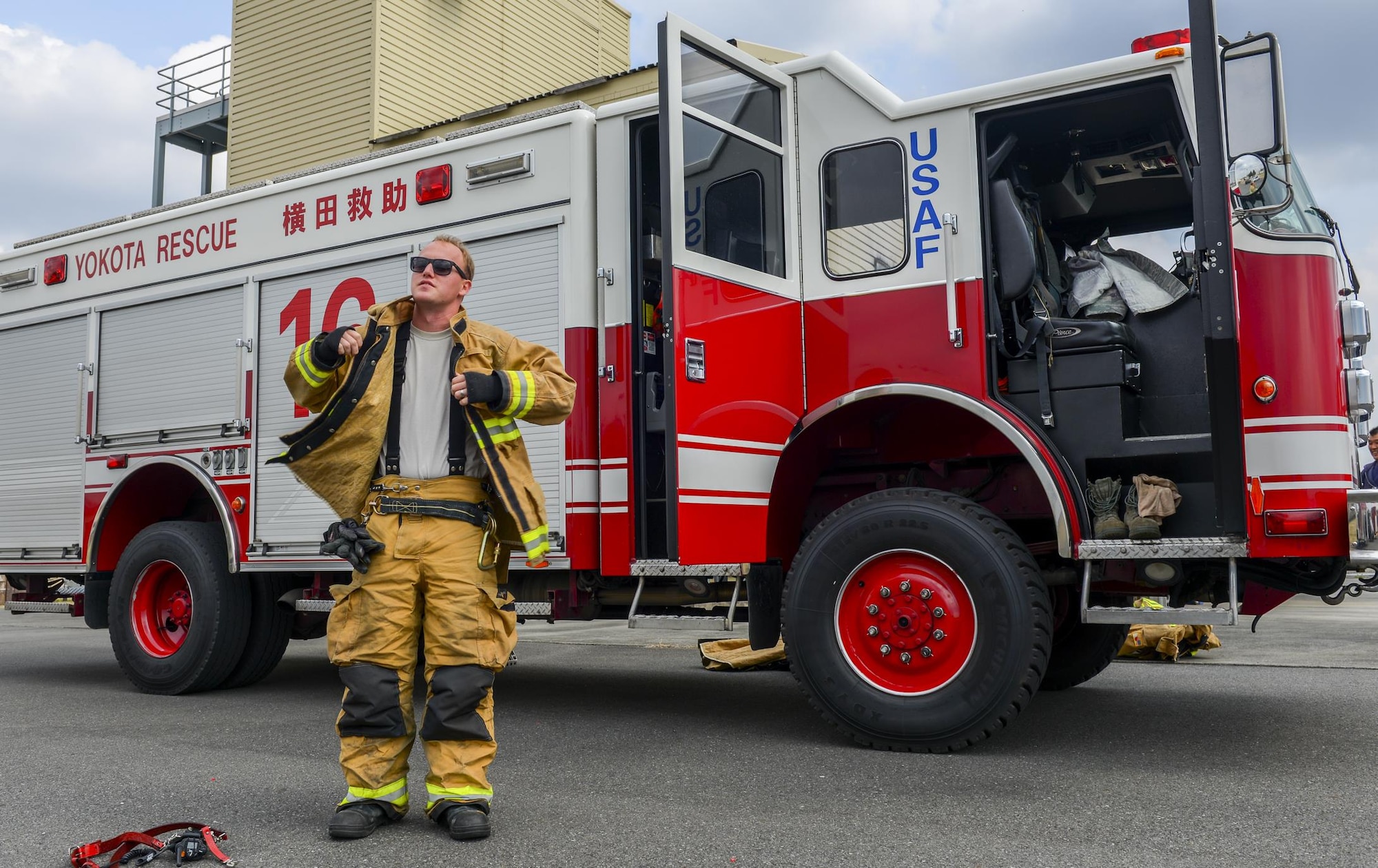 Staff Sgt. Kyle Wirth, 374th Civil Engineer Squadron fire and emergency services flight crew chief, puts on protective gear at Yokota Air Base, Japan, March 28, 2016. Wirth used the gear to protect himself during a mock vehicle extraction, an exercise that involves cutting pieces from a vehicle and properly breaking windows to extract a crash victim without injuring them. (U.S. Air Force photo by Airman 1st Class Elizabeth Baker/Released)
