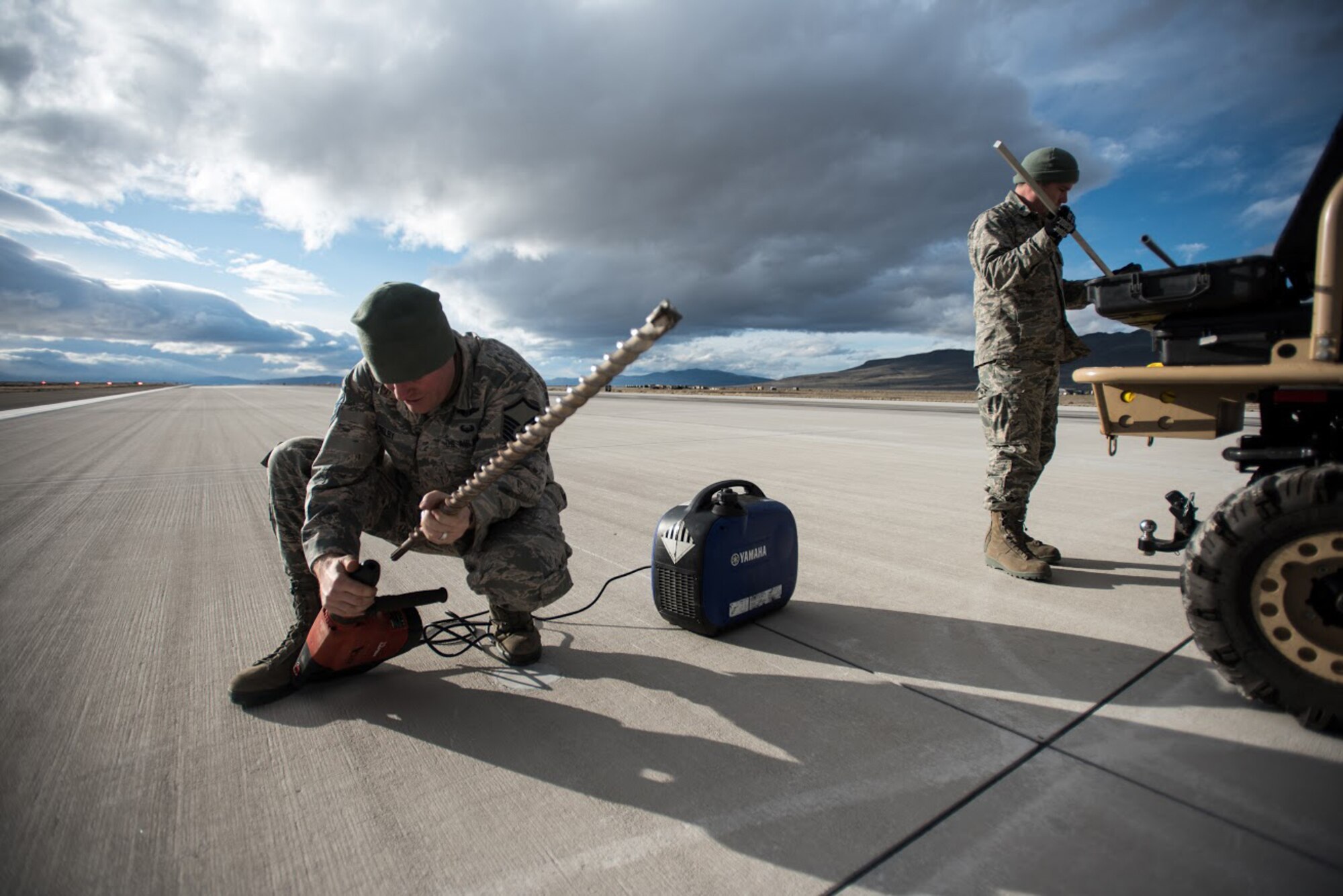 U.S. Air Force Master Sgt. Joshua Selby, ramp coordinator with the Kentucky Air National Guard’s 123rd Contingency Response Group, prepares to drill into the runway at Amedee Army Airfield, Calif., to get a core sample to test the strength of the concrete on March 6, 2016. The 123rd CRG is working in conjunction with the U.S. Army’s 688th Rapid Port Opening Element and a team from the Defense Logistics Agency to operate Joint Task Force-Port Opening Sangala during a week-long exercise called Operation Lumberjack. The objective of the JTF-PO is to establish an aerial port of debarkation, provide initial distribution capability and set up warehousing for distribution beyond a forward node. (Kentucky Air National Guard photo by Master Sgt. Phil Speck)