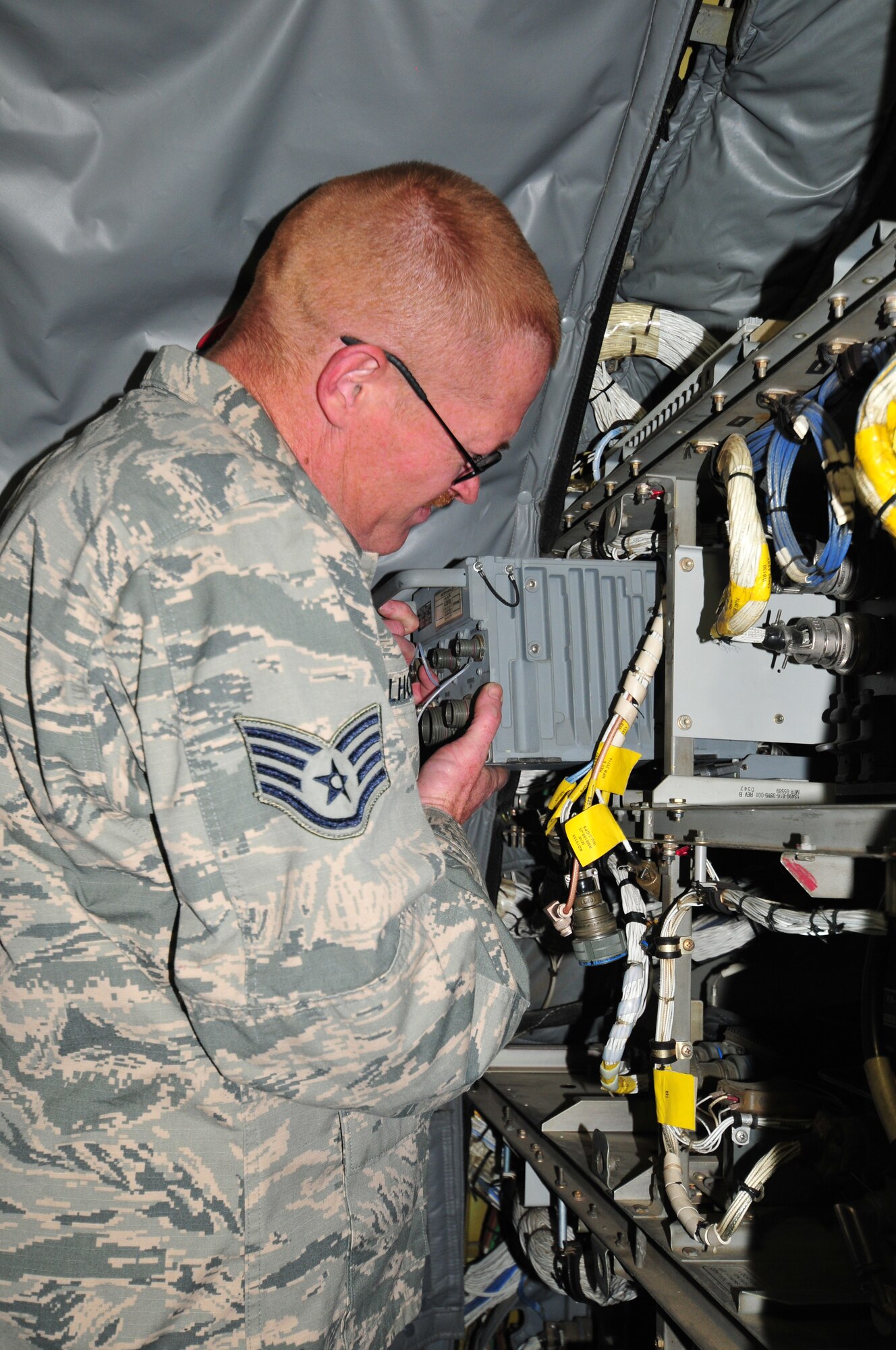 U.S. Air Force Staff Sgt. John Milhoan, 161 Air Refueling Wing communications and navigation specialist, changes out an enhanced GPS inertial navigation unit on a KC-135 Stratotanker.  Milhoan was part of a maintenance repair team sent to Wyoming in March to help out fellow Airmen from Eielson Air Force Base, Alaska. (U. S. Air National Guard photo by Master Sgt. Kelly M. Deitloff)