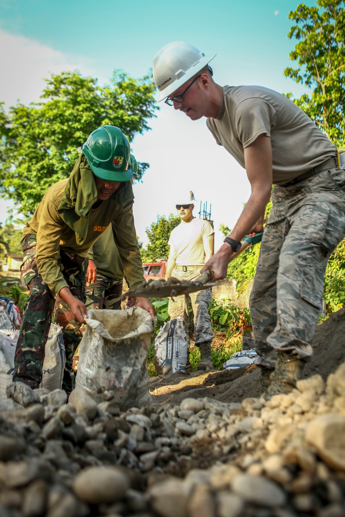 U.S. Air Force Airman 1st Class Jeremy Clapham, right, engineer, assigned to the 673rd Expeditionary Engineer Squadron, and Philippine army soldier Pfc. Ramie Villacampa, left, engineer, assigned to the 552nd Engineer Construction Battalion, shovel gravel to help build a classroom for the Jaena Norte Elementary School, in Capiz, Philippines, during Exercise Balikatan, March 29, 2016. The construction project is one of multiple HCAs taking place during this year's exercise, designed to improve the quality of life for the local populace and strengthen the bond between our two nations. Balikatan, which means "shoulder to shoulder" in Filipino, is an annual bilateral training exercise aimed at improving the ability of Philippine and U.S. military forces to work together during planning, contingency and humanitarian assistance and disaster relief operations.  (U.S. Marine Corps Combat Camera photo by Cpl. Hilda M. Becerra / Released)