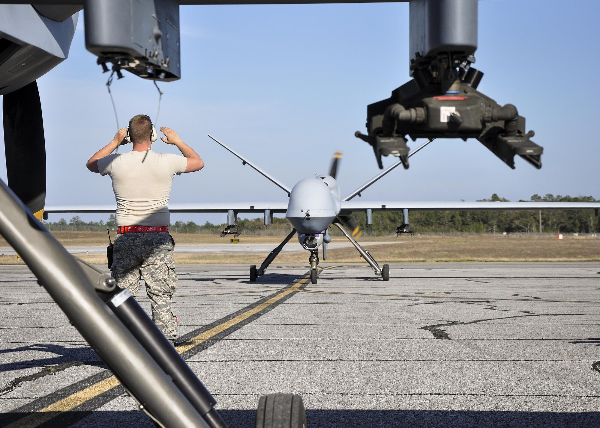 Senior Airman Wyatt, 49th Aircraft Maintenance Squadron crew chief, marshals an MQ-9 Reaper on the flightline March 15, at Duke Field, Fla. Students of the MQ-9 platform from the 26th Weapons Squadron, U.S. Air Force Weapons School, Nellis AFB, Nev., participated in the Weapons System Evaluation Program for a unique training opportunity – engaging maritime threats. (U.S. Air Force photo by Susan Garcia)