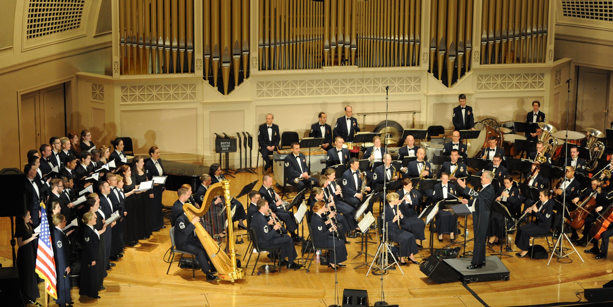 Col. Larry Lang conducts Eastern Michigan University students
along with the Concert Band and Singing Sergeants during a performance at EMU in Ypsilanti, Mich., on April 9, 2014. These groups will perform at various venues throughout Ark., La., Miss., Tenn., and Texas on their upcoming spring tour. (U.S. Air Force photo by Master Sgt. Tammie Moore/released)