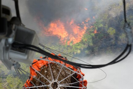 A U.S. Army CH-47 Chinook uses a Bambi Bucket to drop water on a fire April 1, 2016, near Tela, Honduras, at the request of Honduran President Juan Orlando Hernandez. The Chinooks were a part of aircraft from the 1-228th Aviation Regiment to support the Honduran Fire Department, Air Force and Army in the firefighting efforts. (U.S. Air Force photo by Staff Sgt. Westin Warburton/ Released)
