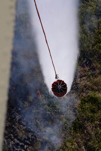 A U.S. Army CH-47 Chinook uses a Bambi Bucket to drop water on a fire March 31, 2016, near Tela, Honduras, at the request of Honduran President Juan Orlando Hernandez. The Chinooks were a part of aircraft from the 1-228th Aviation Regiment to support the Honduran Fire Department, Air Force and Army in the firefighting efforts. (U.S. Air Force photo by Staff Sgt. Westin Warburton/ Released)