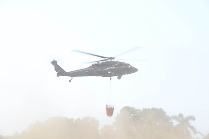 A U.S. Army UH-60 Black Hawk with the 1-228th Aviation Regiment takes off with a Bambi Bucket March 31, 2016, Tela, Honduras, to respond to a request from Honduran President Juan Orlando Hernandez for support in extinguishing a forest fire near Tela. The Honduran Fire Department, Air Force and Army worked with U.S. air assets from Joint Task Force-Bravo at Soto Cano Air Base, Honduras, to control and extinguish the fire. (U.S. Air Force photo by Staff Sgt. Westin Warburton/ Released)