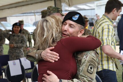 Col. Miguel Castellanos, outgoing commander of the 361st Civil Affairs Brigade, hugs Stacey Novak, wife of the incoming commander Col. John Novak after the 361st change of command ceremony Sunday, April 3, 2016 at Daenner Kaserne in Kaiserslautern, Germany.