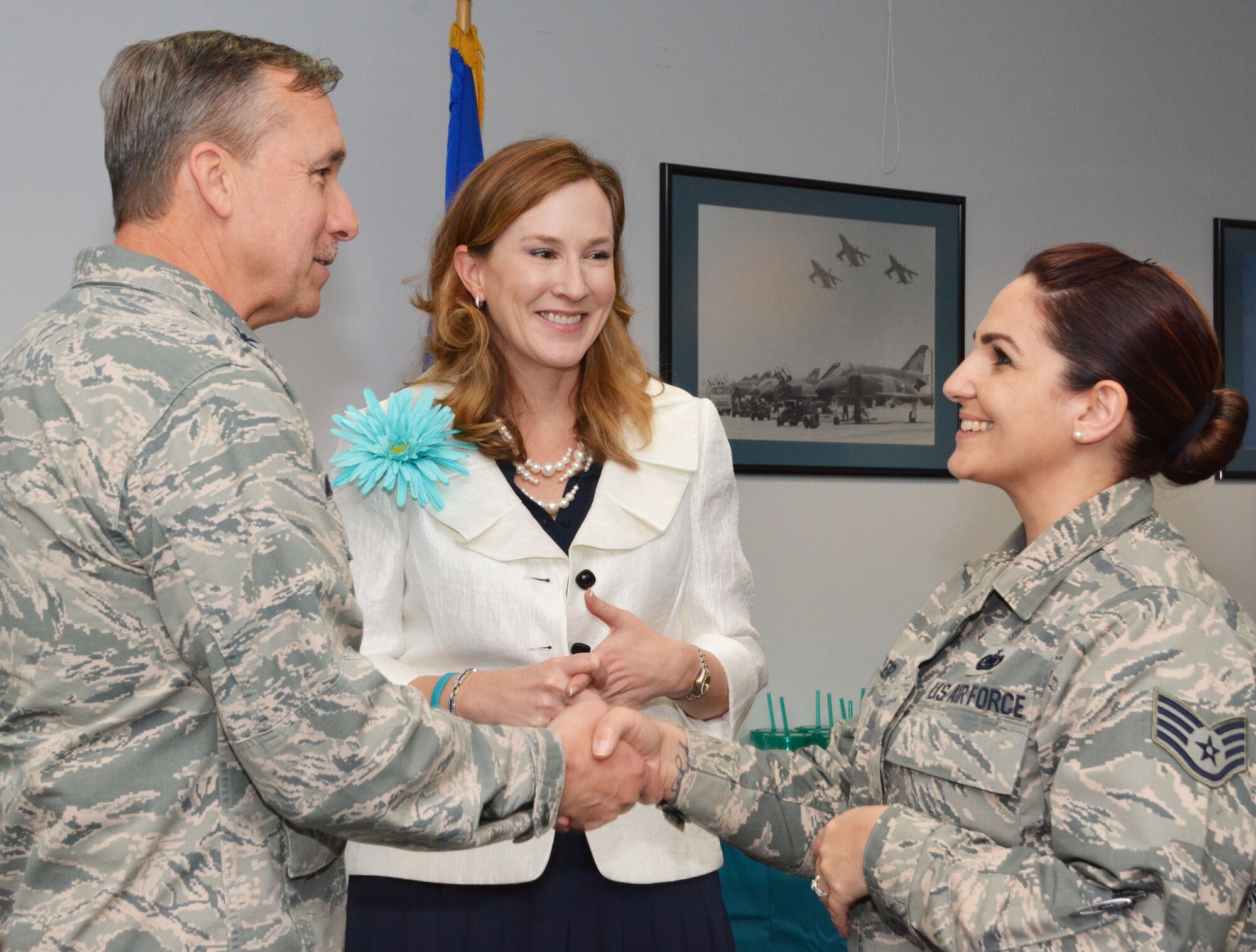 Staff Sgt. Stephanie Miller, 301st Medical Squadron mental health technician, shakes the hand of Col. John Breazeale, 301st Fighter Wing commander, here April 1 while Mrs. Laura Loftin, 301st Fighter Wing sexual assault response coordinator, smiles on. Miller worked as a volunteer victim advocate to support, counsel, and assist sexual assault victims through reporting processes.