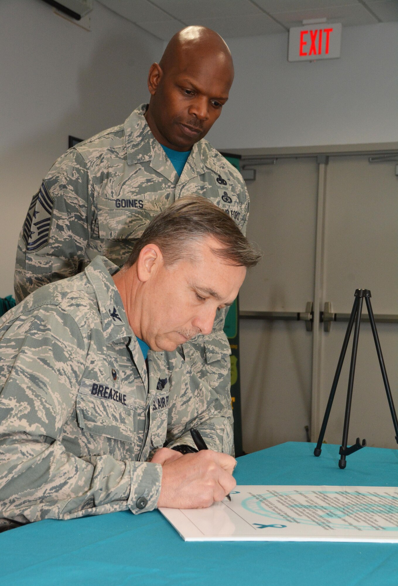 Col. John Breazeale, 301st Fighter Wing commander, signs a proclamation here declaring April 2016 as Sexual Assault Awareness month April 1, while Chief Master Sgt. Terry Goines, 301st Fighter Wing command chief, looks on. Members of the 301st Fighter Wing can wear a teal shirt on Tuesdays in April to promote awareness of sexual assault. 