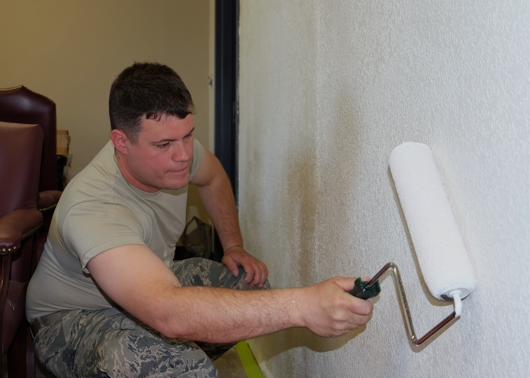 Staff Sgt. Brandon Smith, 931st Civil Engineer Squadron Structures journeyman, paints over a section of wall that was a doorway less than 24 hours before Smith began painting April 3, 2016, at McConnell Air Force Base, Kansas. The door was closed off to allow for more space in the next office and control the number of entry points. (U.S. Air Force photo by Senior Airman Preston Webb)